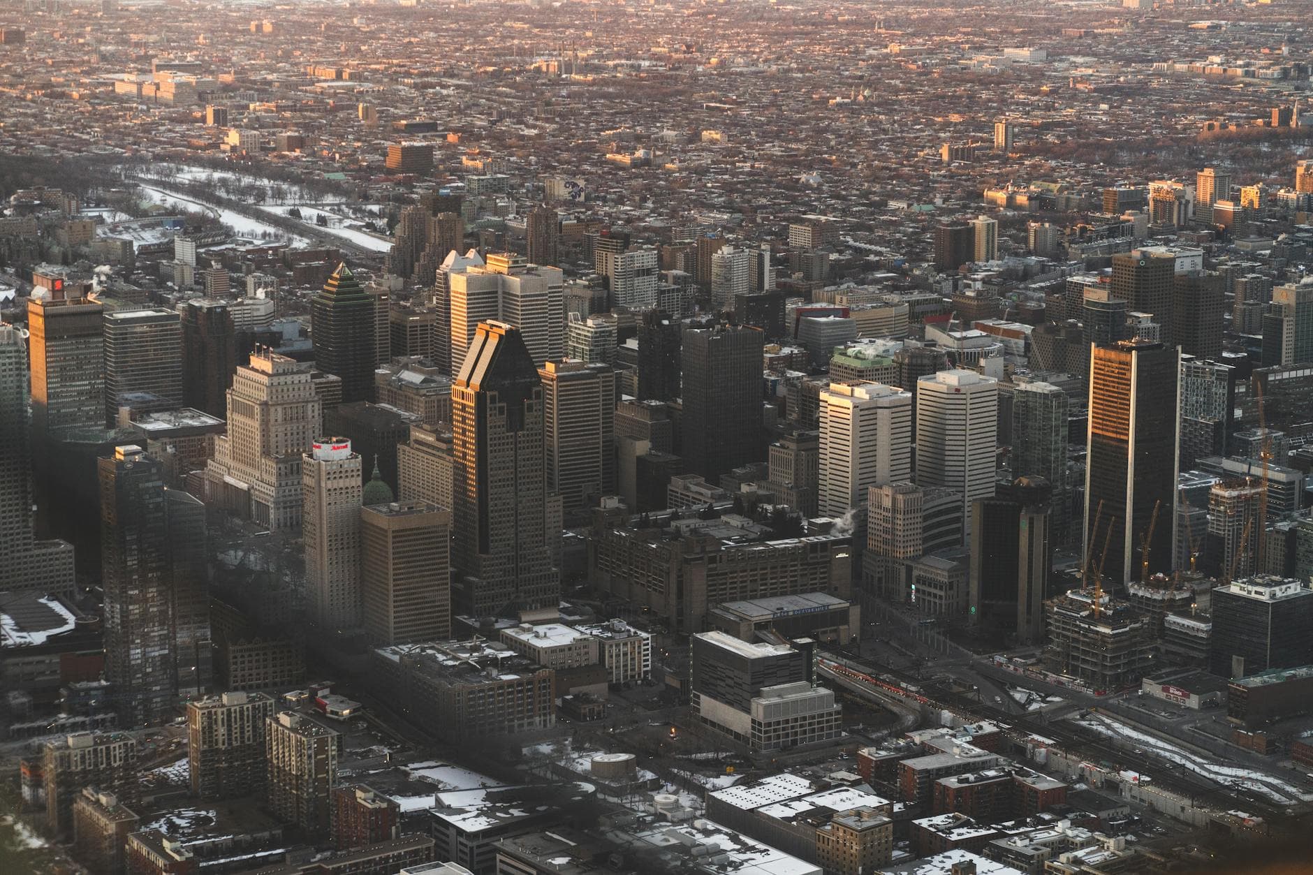 Discover Montreal's bustling skyline with this stunning aerial view capturing modern architecture at sunset.