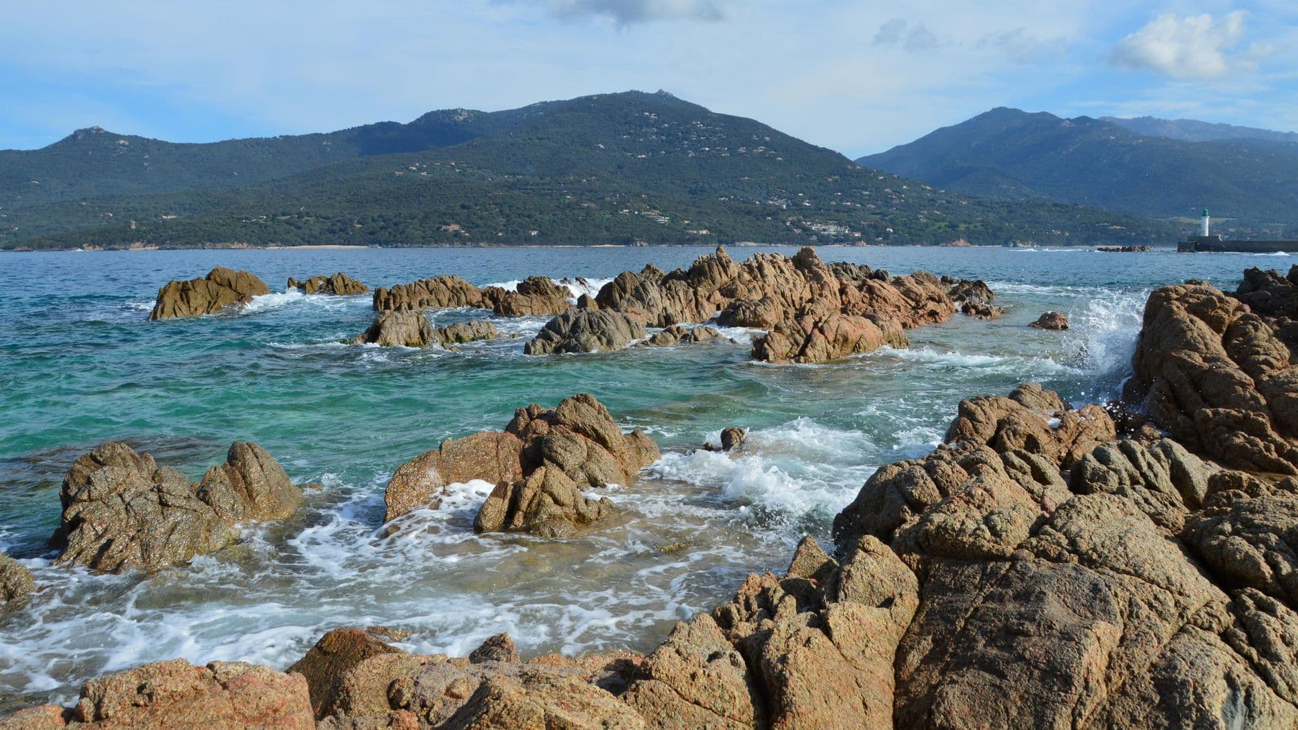 Breathtaking view of rocky coast and sea in Corsica, France under clear skies.