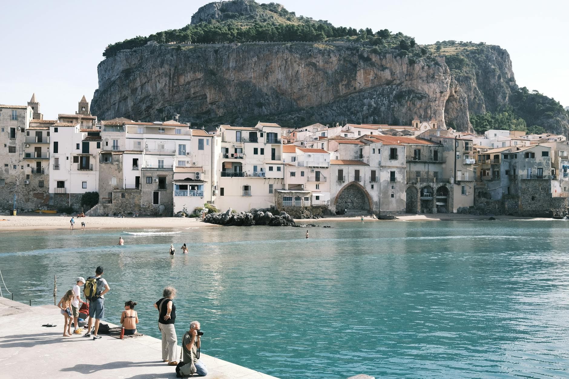 Charming coastal view of Cefalù, Sicily with historic buildings and clear waters.