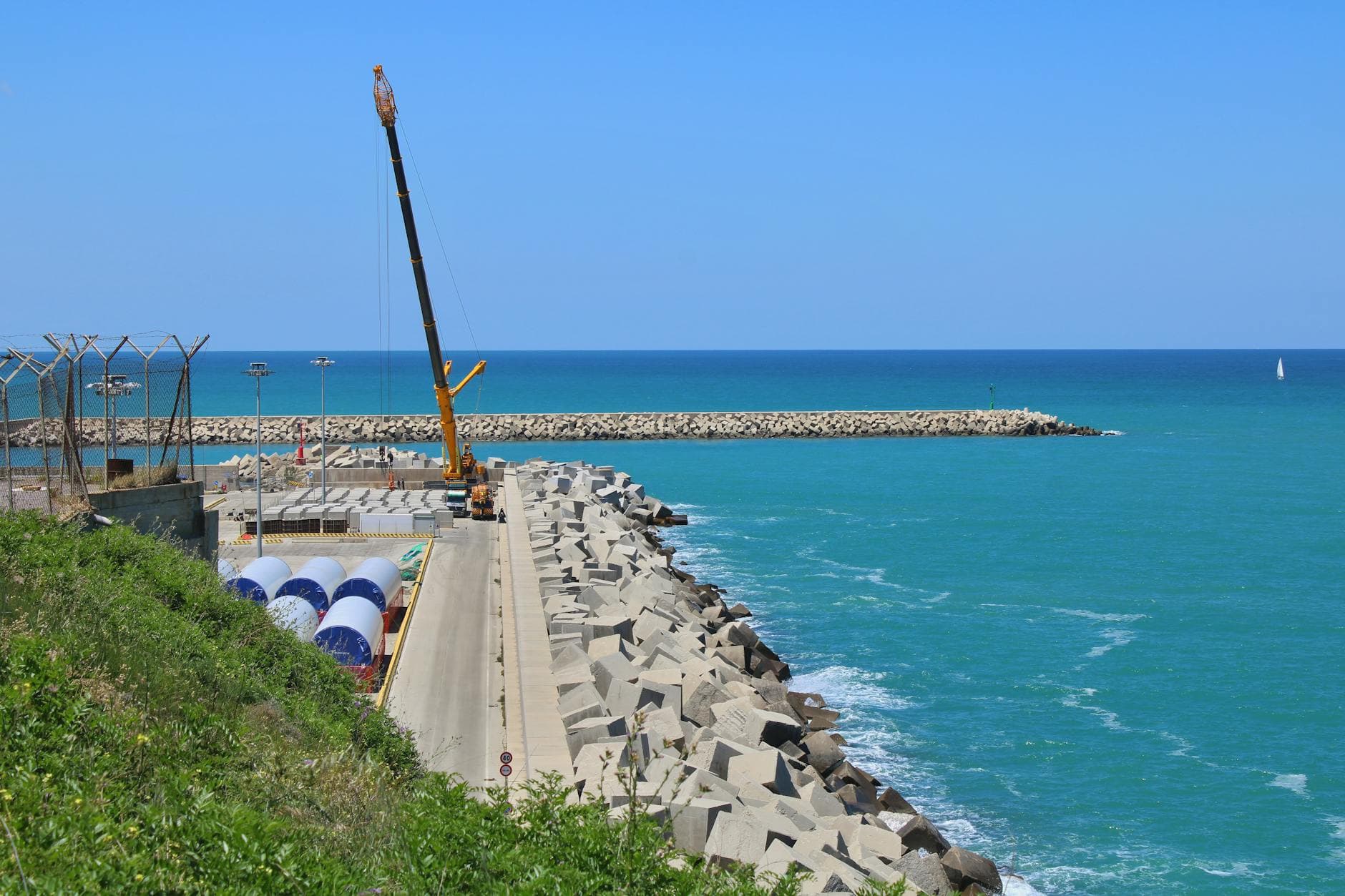 Explore the stunning marina in Vasto, Italy, featuring a serene blue sea and industrial cranes.