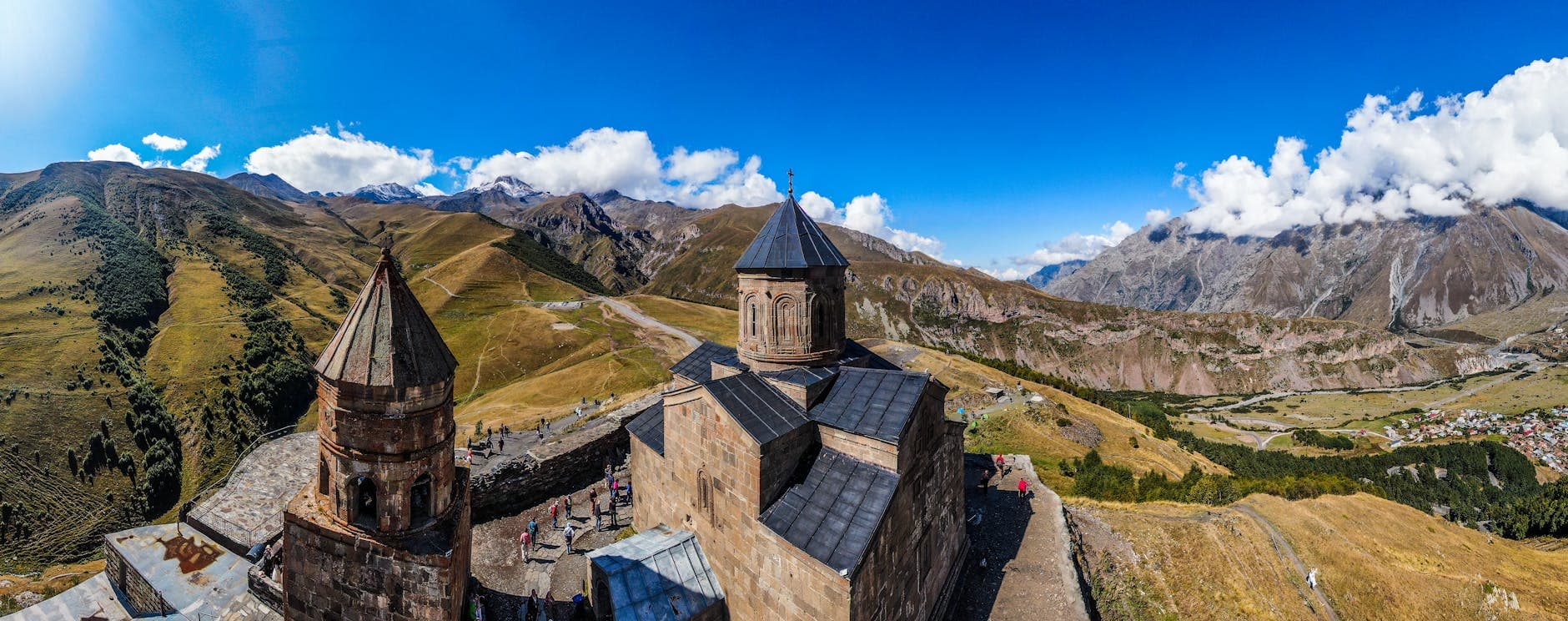 Stunning aerial view of Gergeti Trinity Church against the backdrop of the majestic Caucasus Mountains.