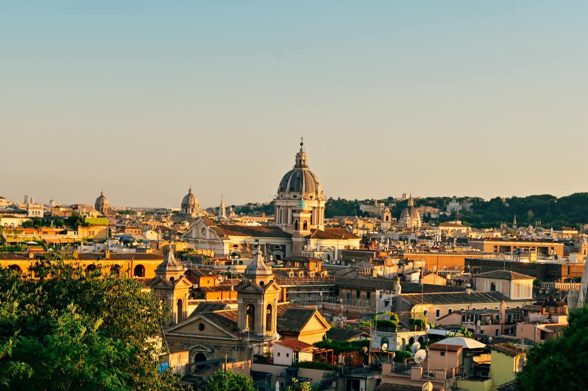 Capture the timeless beauty of Rome's skyline at sunset with its iconic domes and ancient buildings.