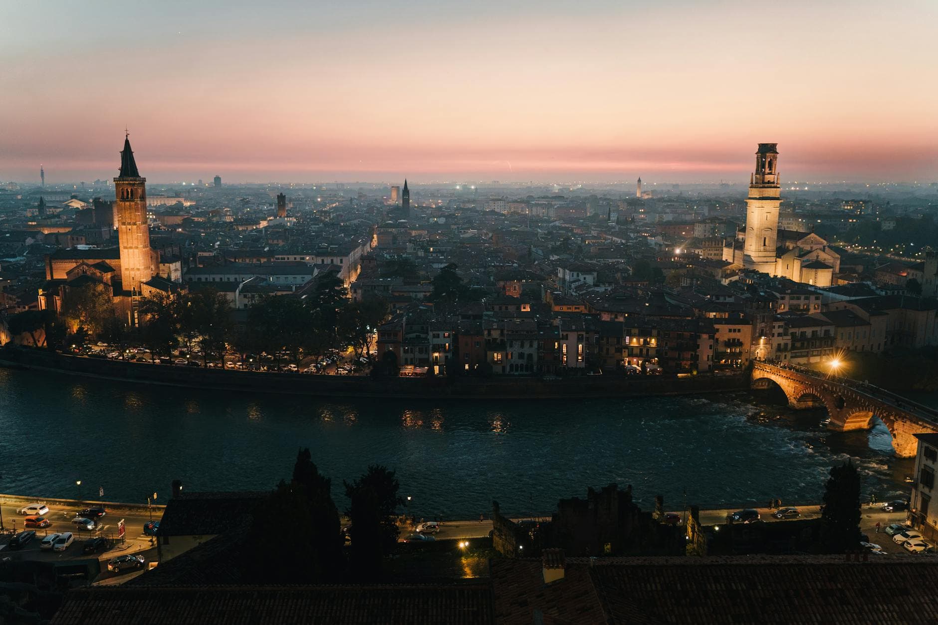 Stunning view of Verona, Italy's skyline at sunset, showcasing historic architecture and the tranquil river.