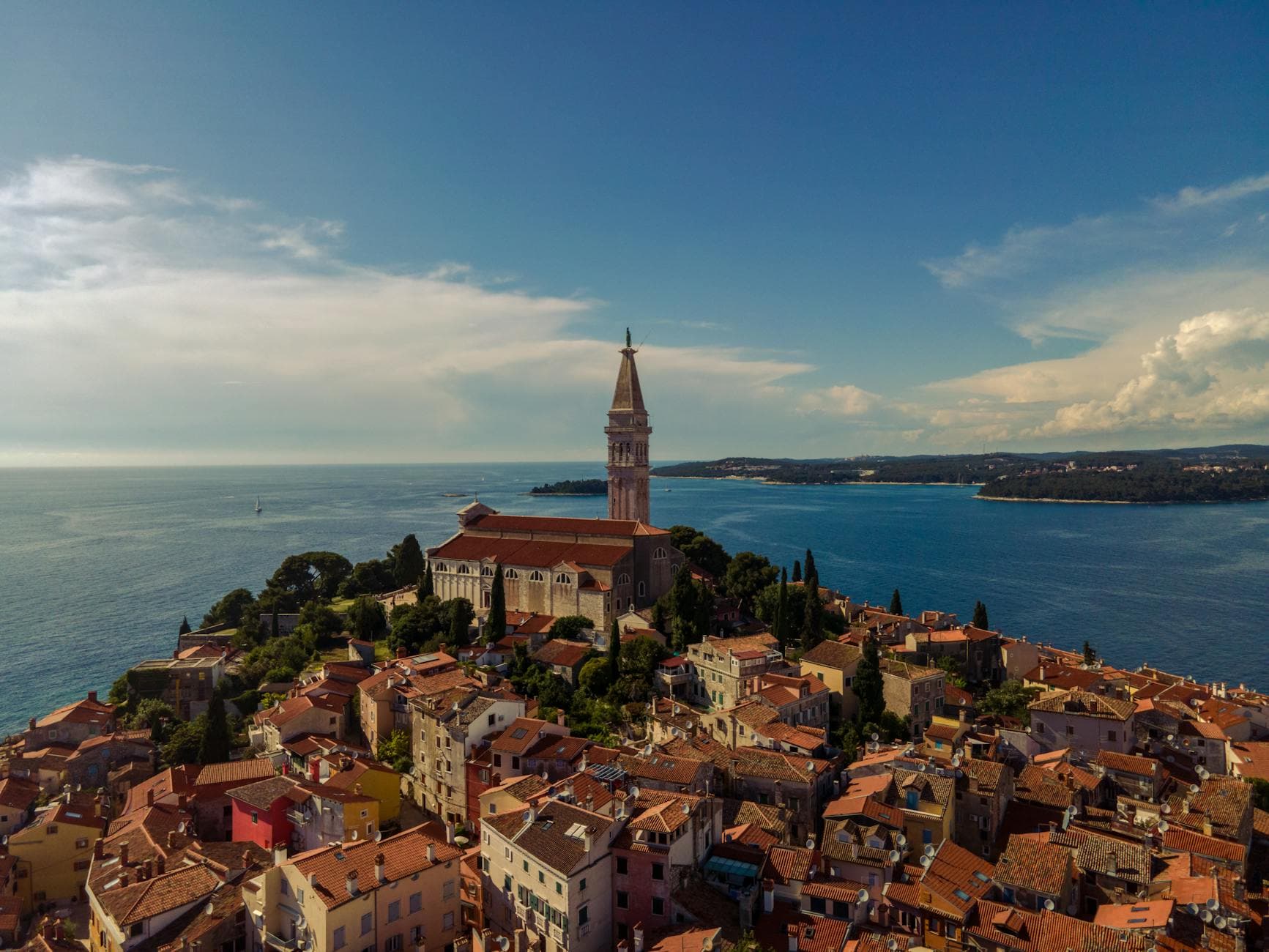 Aerial photo of Rovinj, Croatia, highlighting its historic church tower and coastal scenery.