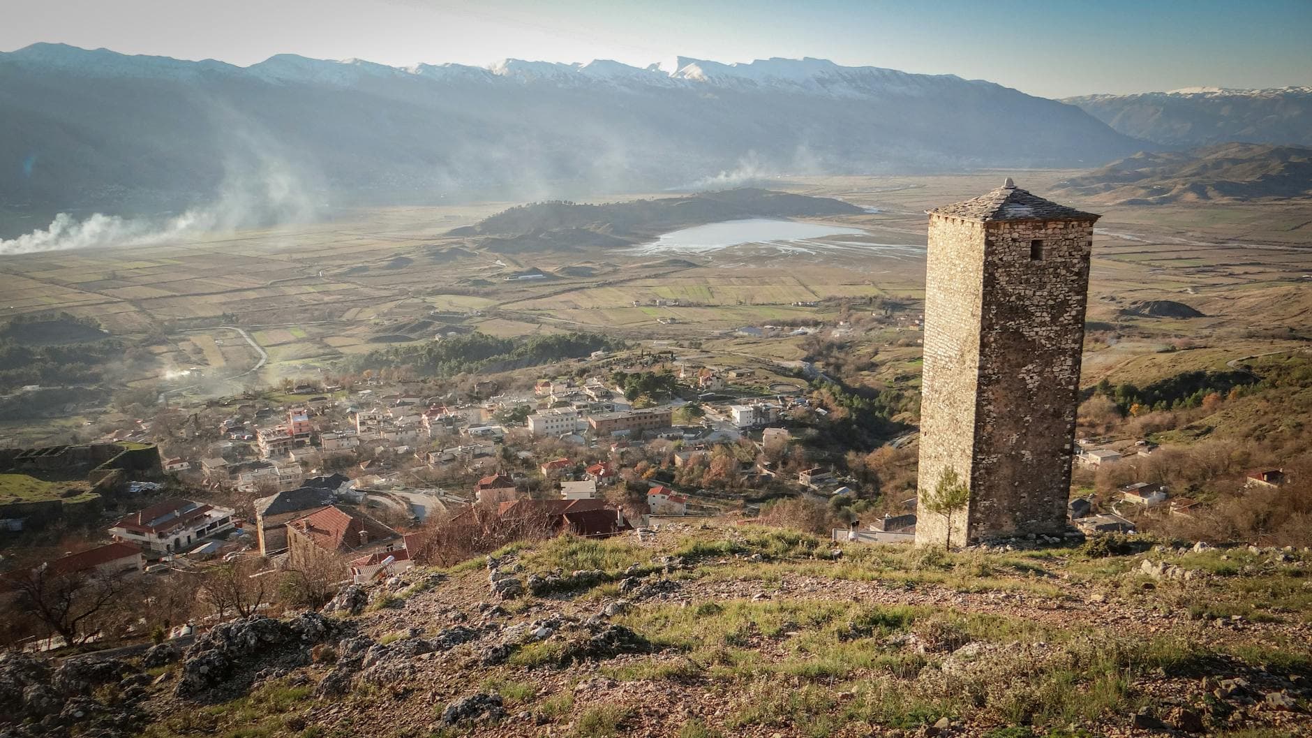 Panoramic view of a historic stone tower overlooking the landscape and mountains of Albania.