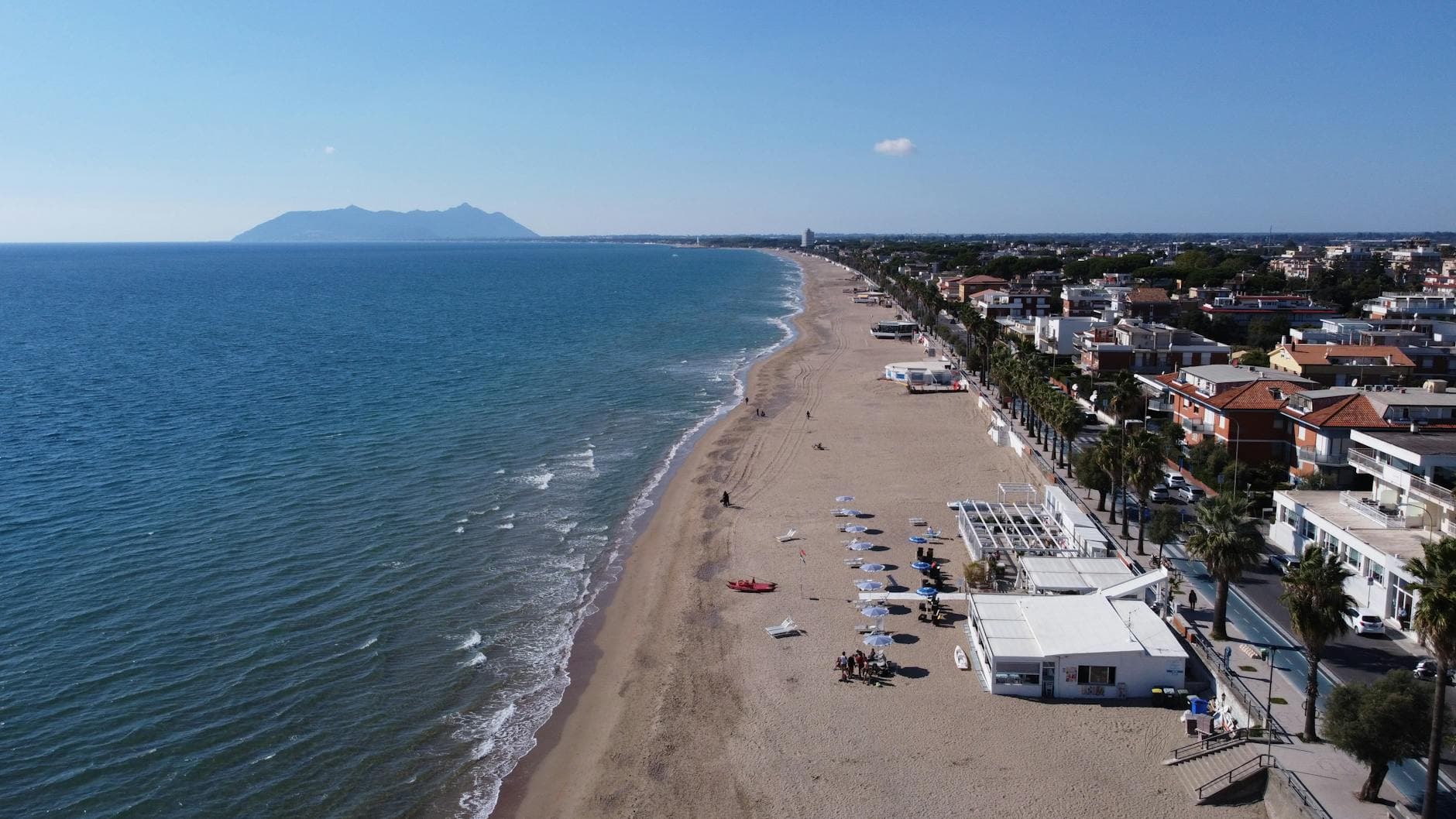 Drone capture of a serene beach and shoreline in Latina, Lazio, Italy.