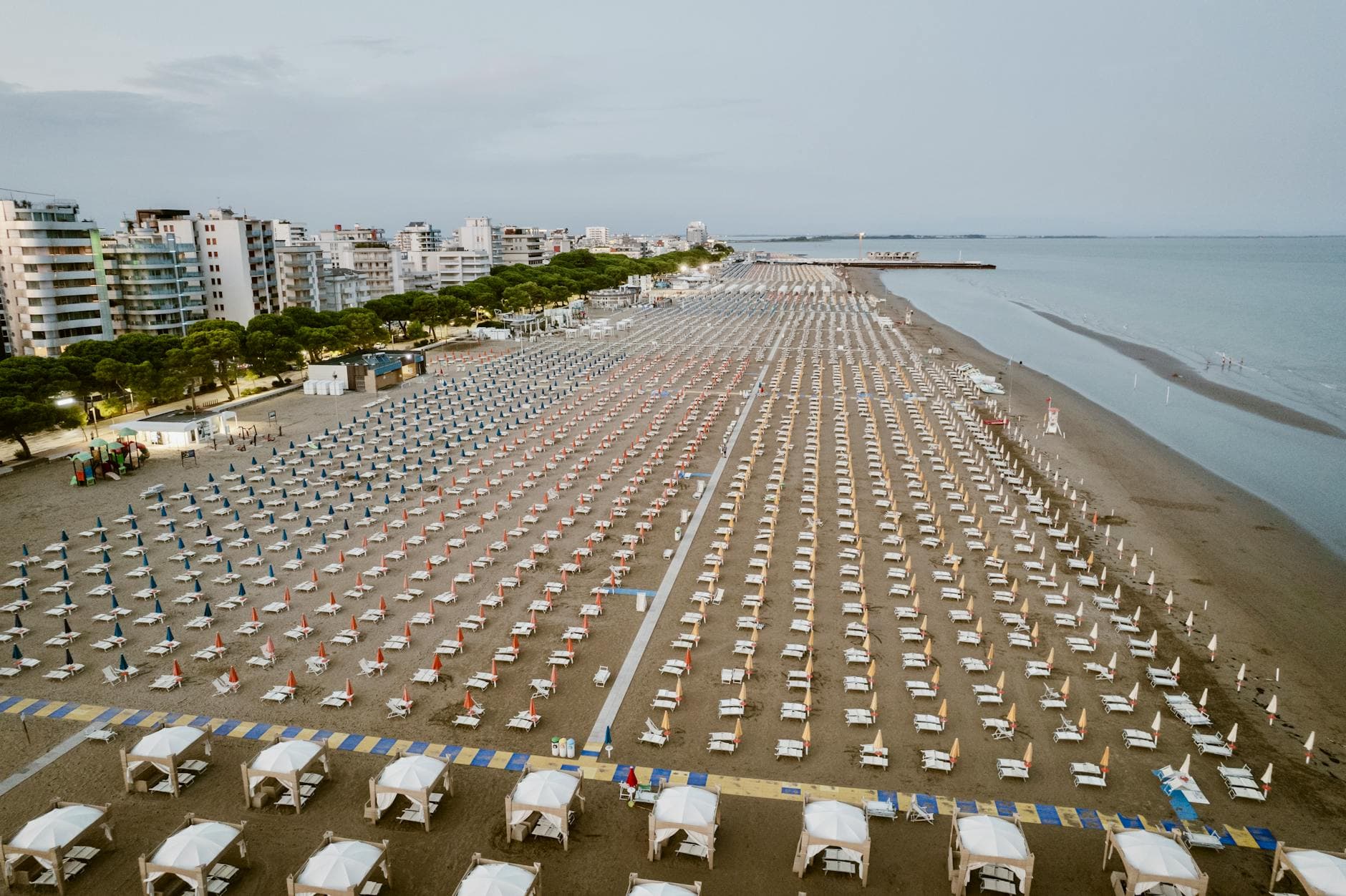 Aerial view of sunbeds and umbrellas on Lignano Sabbiadoro beach, Italy.