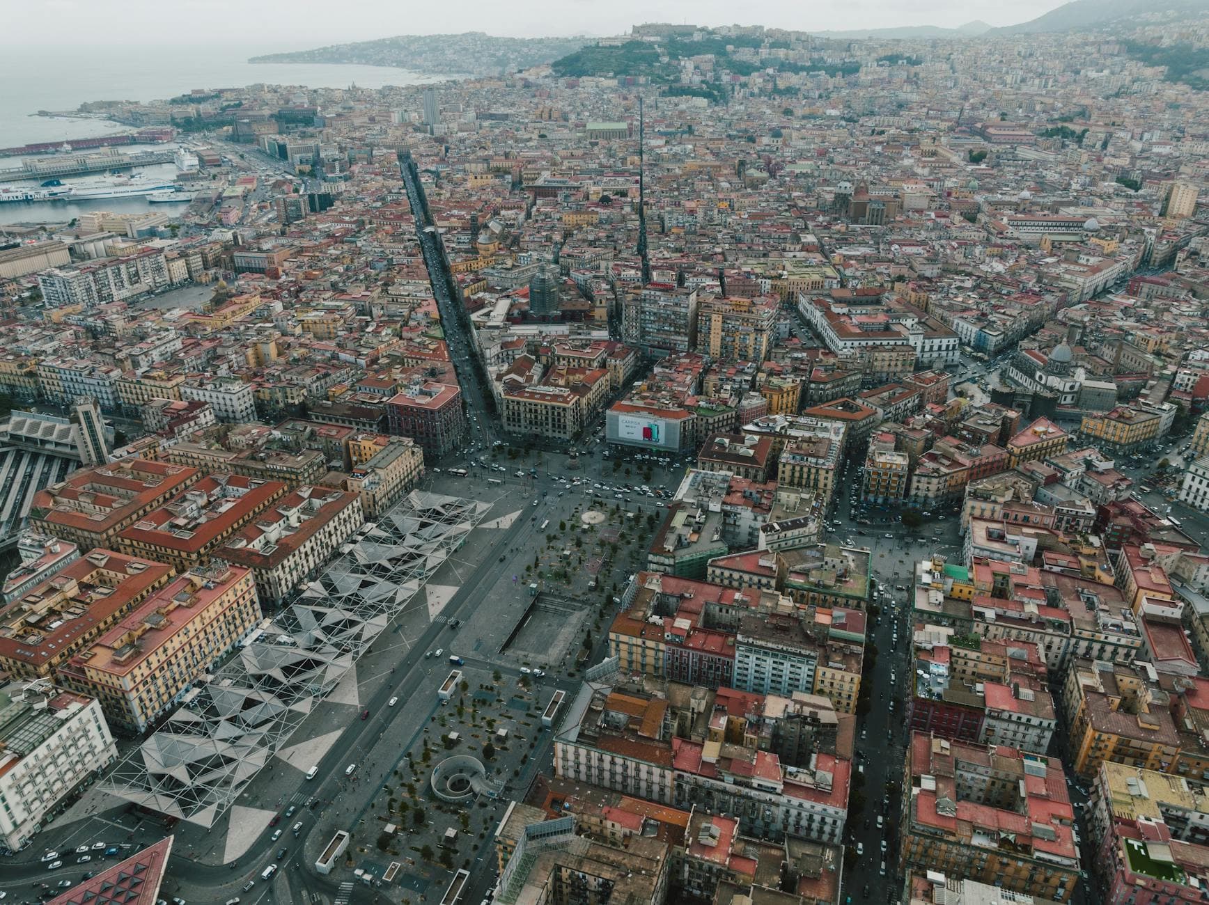 Stunning aerial view of Napoli showcasing dense urban landscape with iconic architecture and coastline.