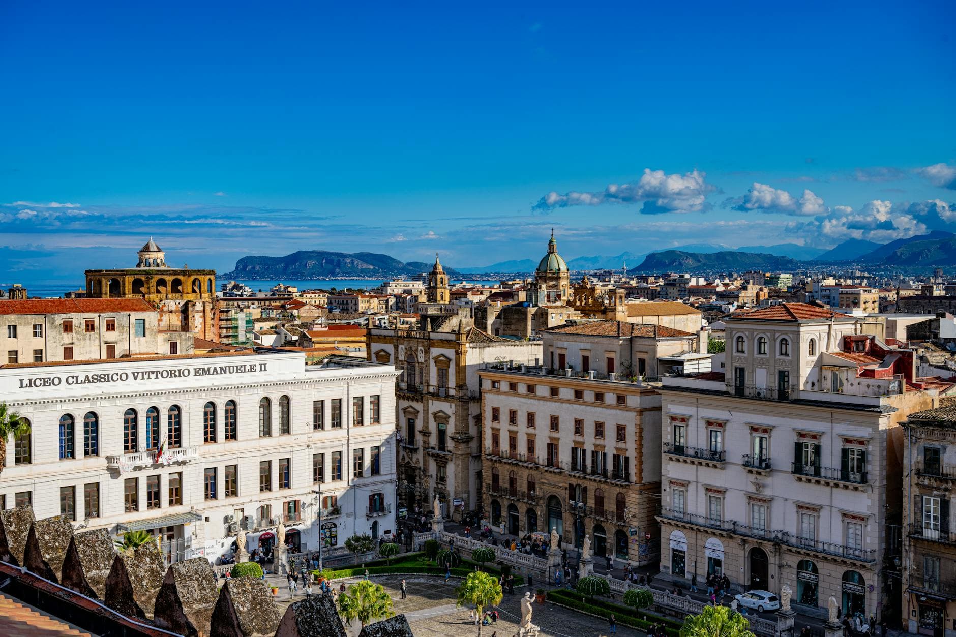 A picturesque view of Palermo's historic architecture under a bright blue sky in Sicily, Italy.