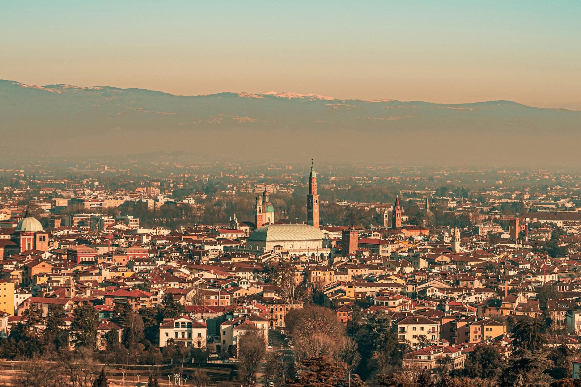 Aerial view of Vicenza, Italy showcasing architecture with mountains in the background.