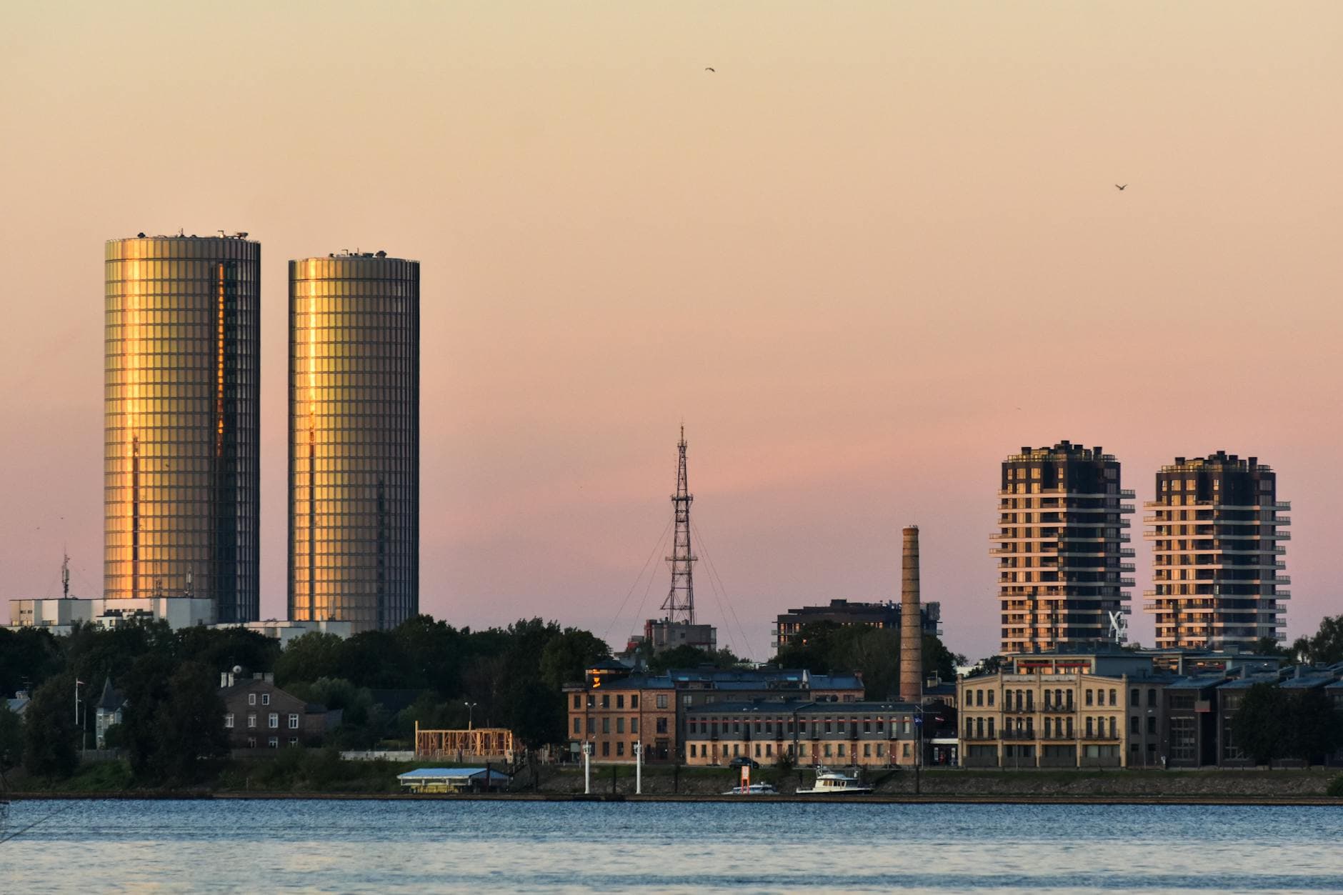 View of Riga's skyline during sunset, showcasing the iconic Z-Towers and surrounding structures.
