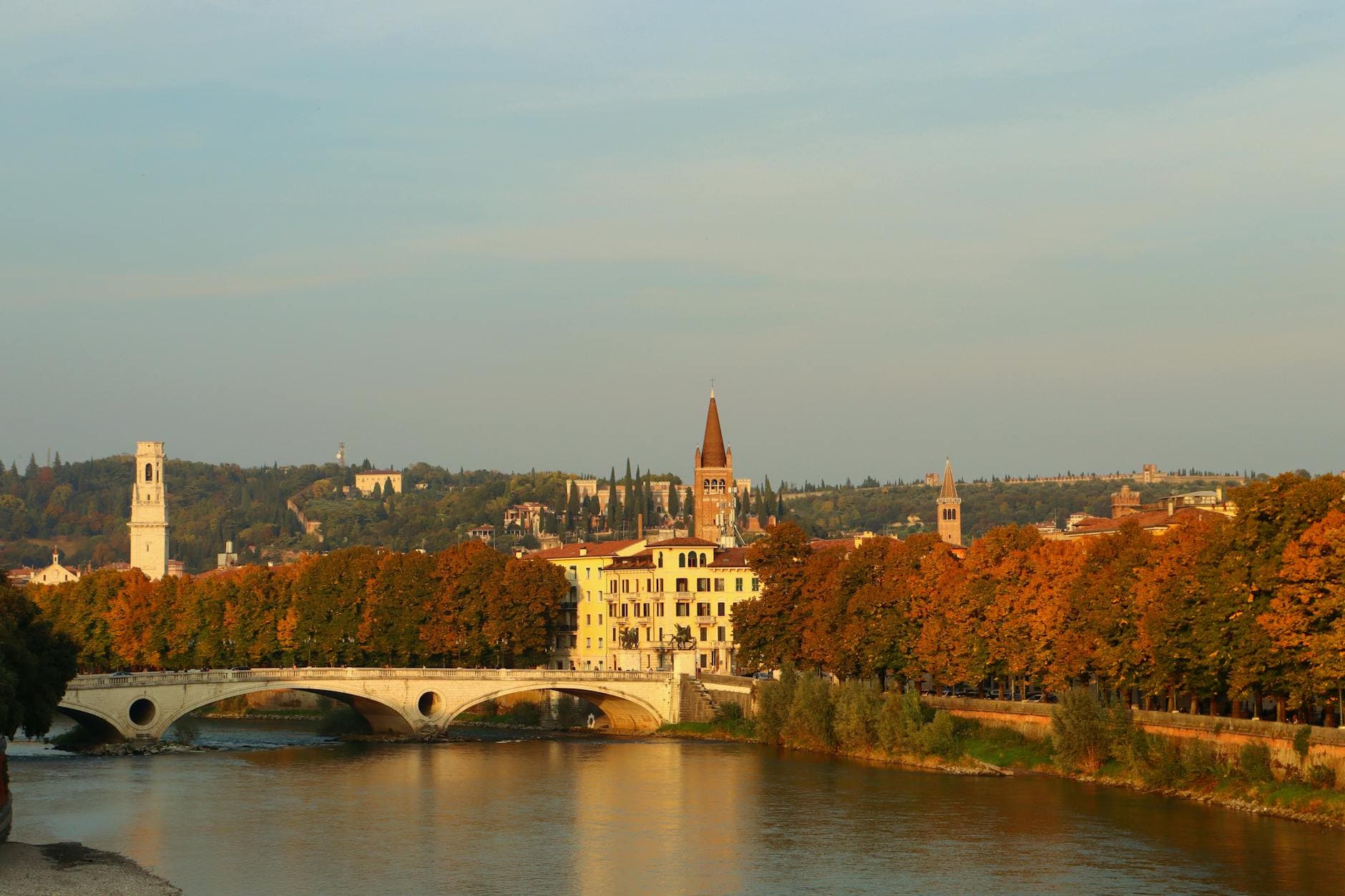 Scenic autumn landscape of Verona, Italy featuring the historic Ponte Pietra bridge.