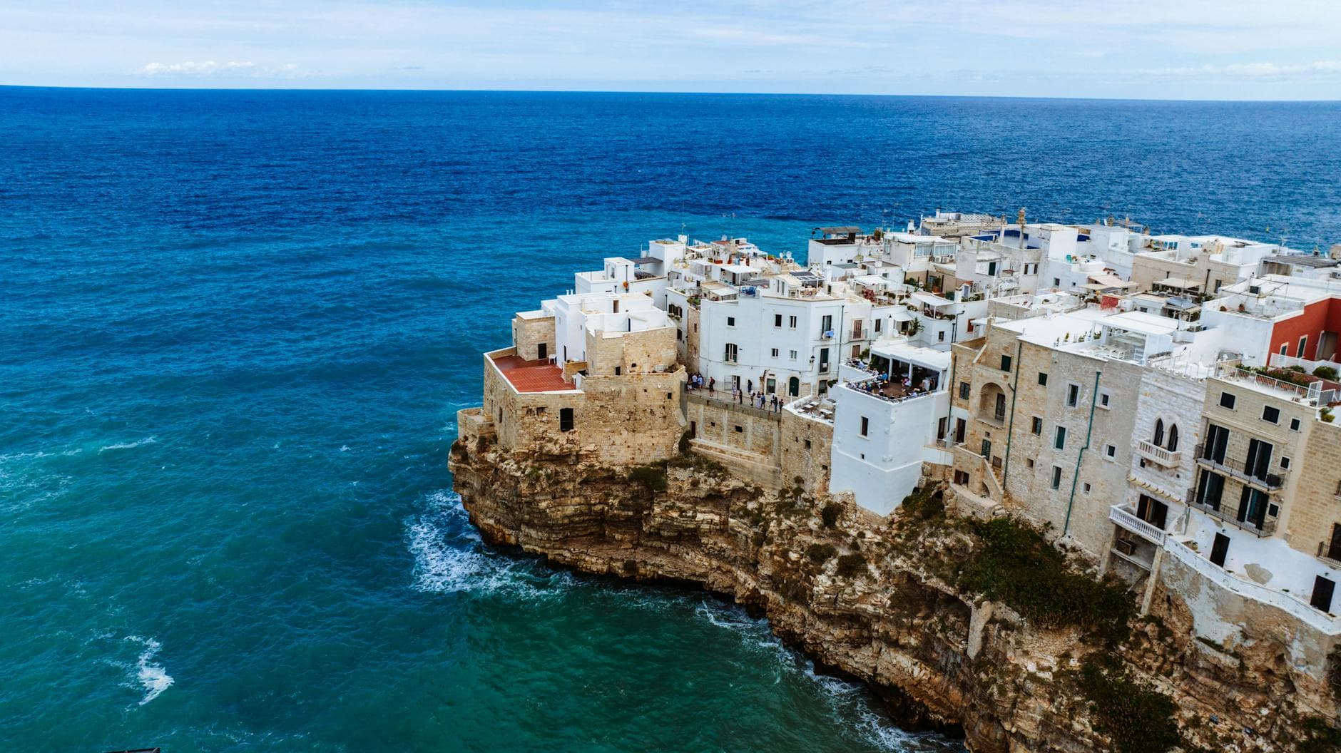 Scenic aerial view of Polignano a Mare's historic clifftop town by the Mediterranean Sea.