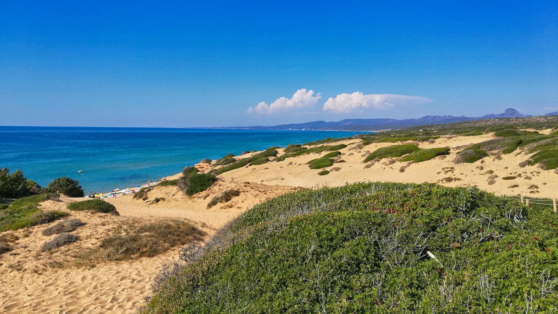 Breathtaking view of the golden dunes and azure sea at Piscinas, Sardinia, Italy.