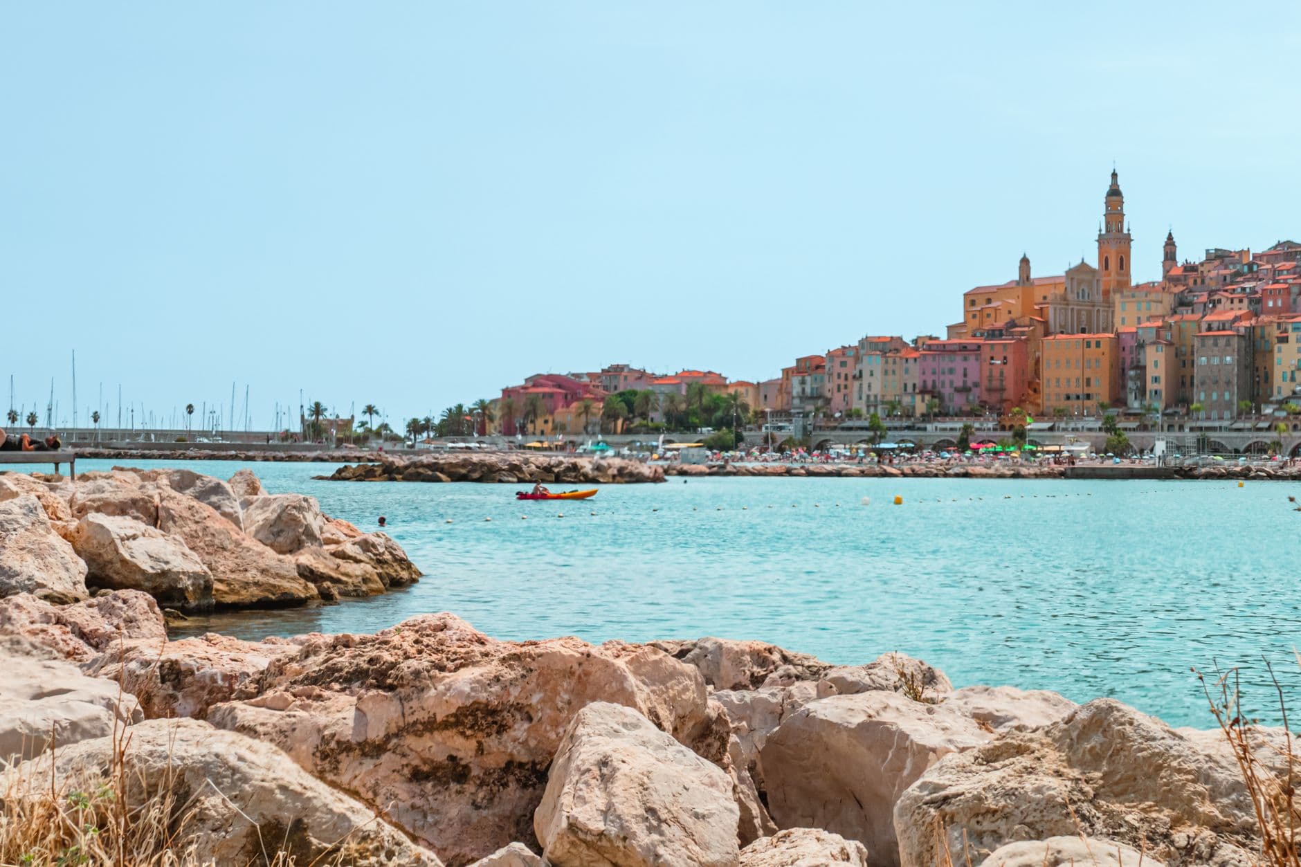 Picturesque view of Menton's vibrant coastline and historic architecture under a clear sky.