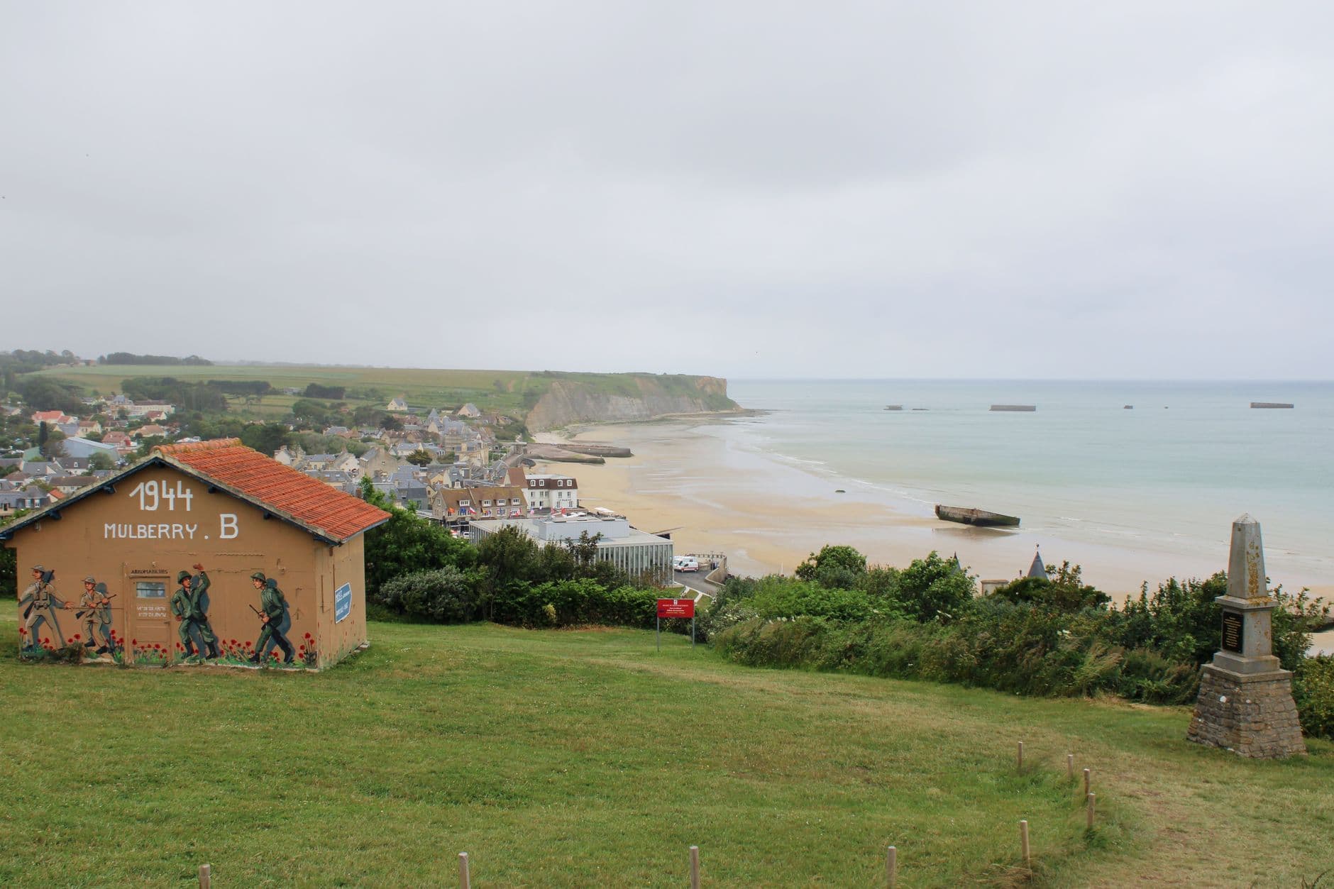 Historic Arromanches-les-Bains coastline featuring Mulberry B remains from WWII.