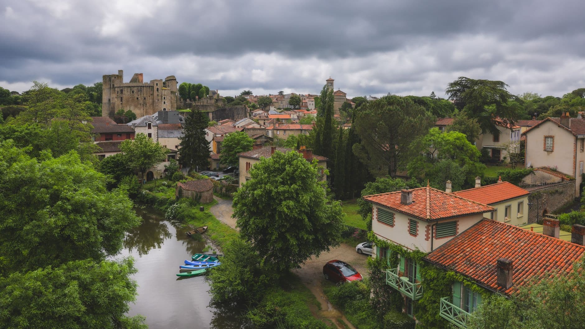 Picturesque landscape of Clisson, France showcasing its iconic castle amidst lush greenery and charming homes.