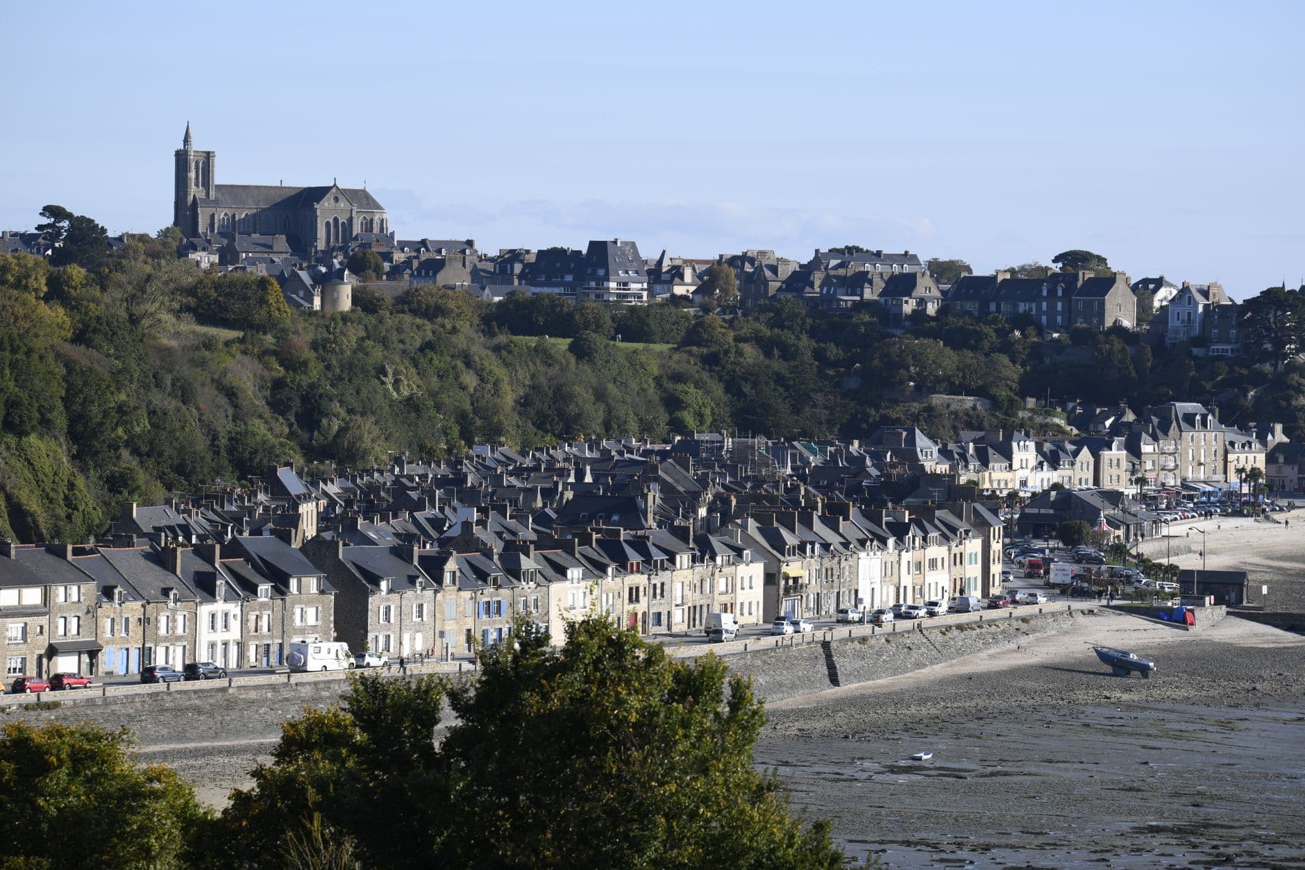 A scenic view of Granville, France, showcasing coastal houses and a historic church.