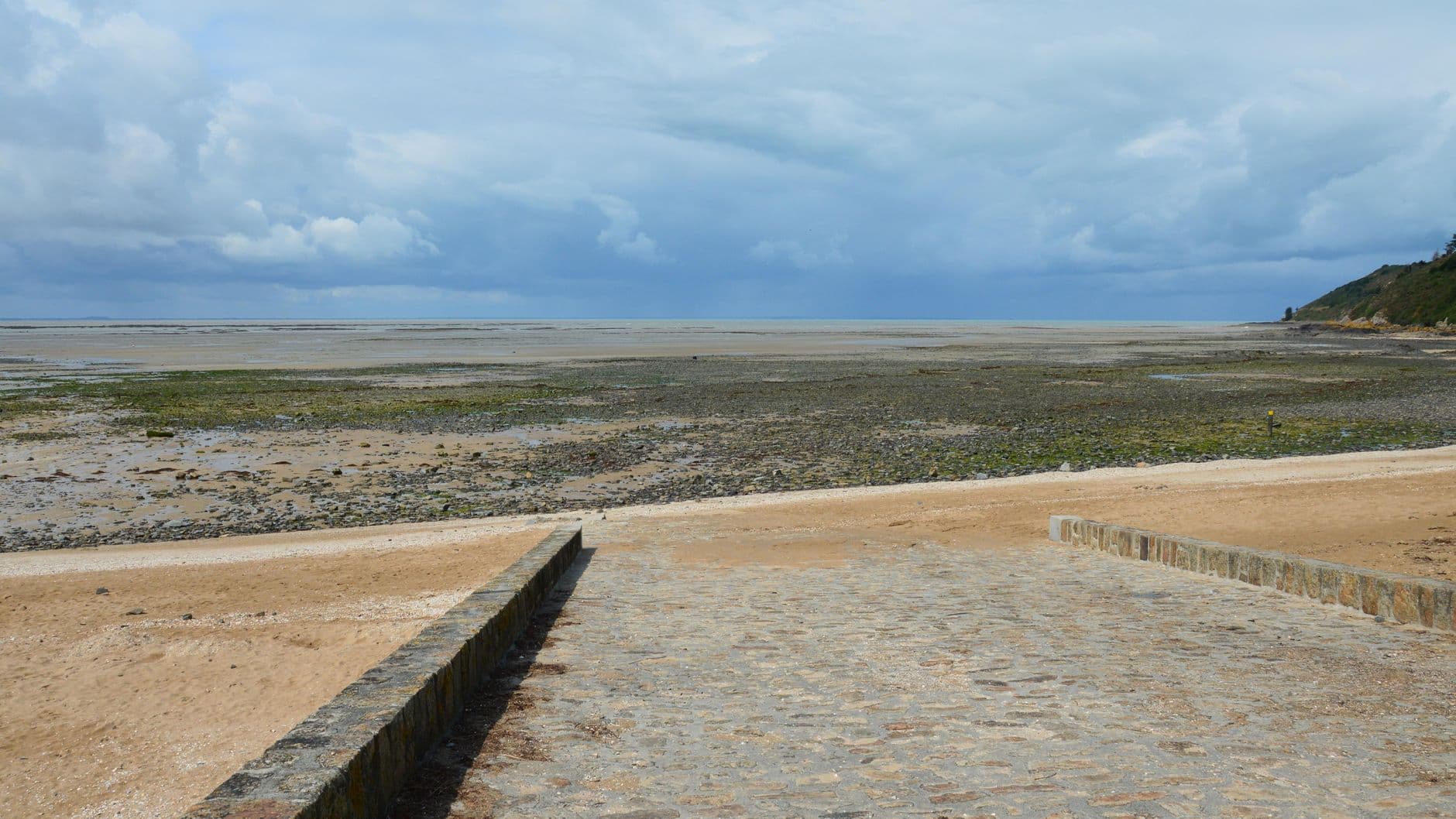 Tranquil view of the beach during low tide at Saint-Jean-le-Thomas, Normandie, France.