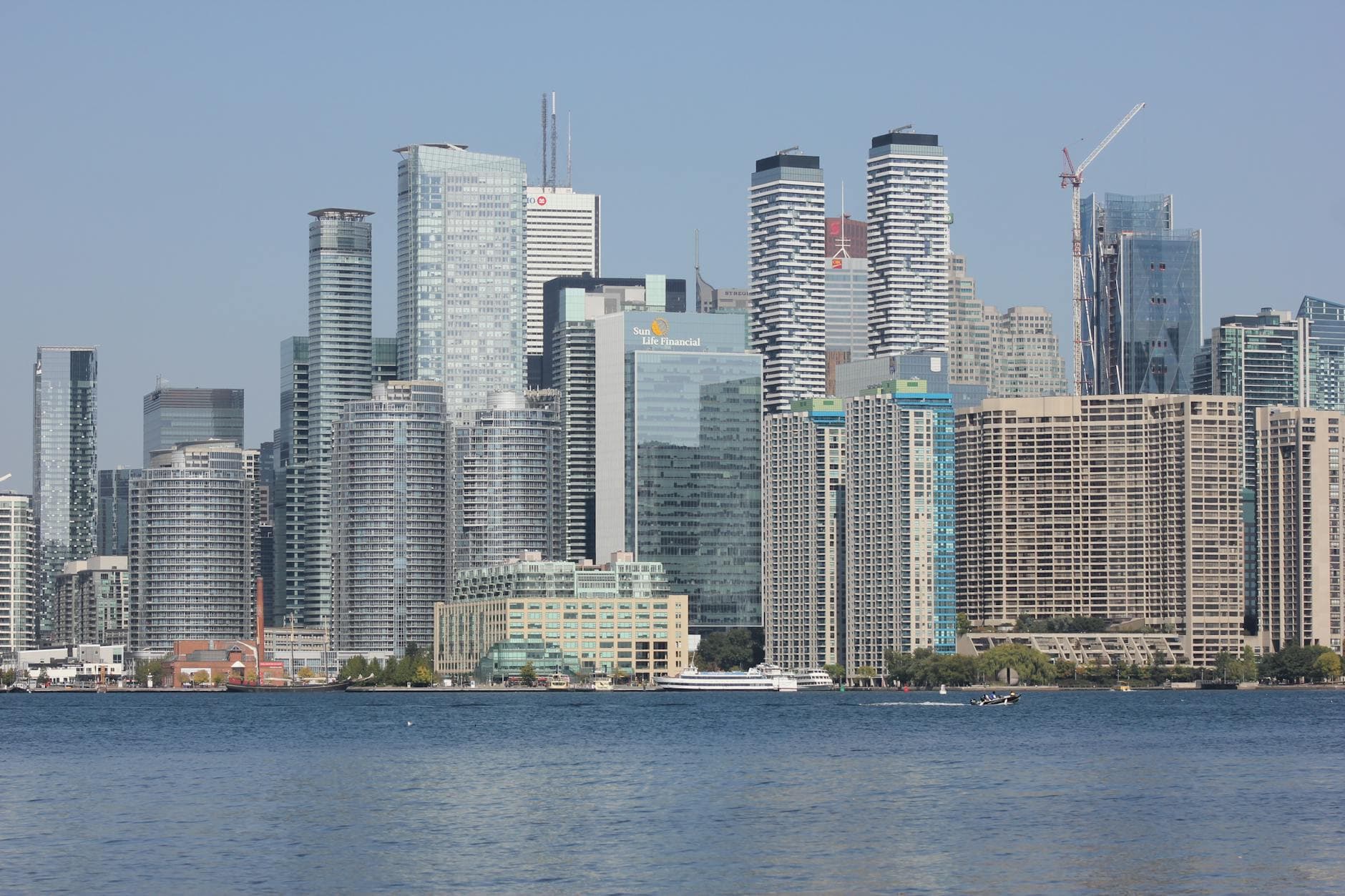 High-rise buildings in downtown Toronto with a waterfront view under clear skies.