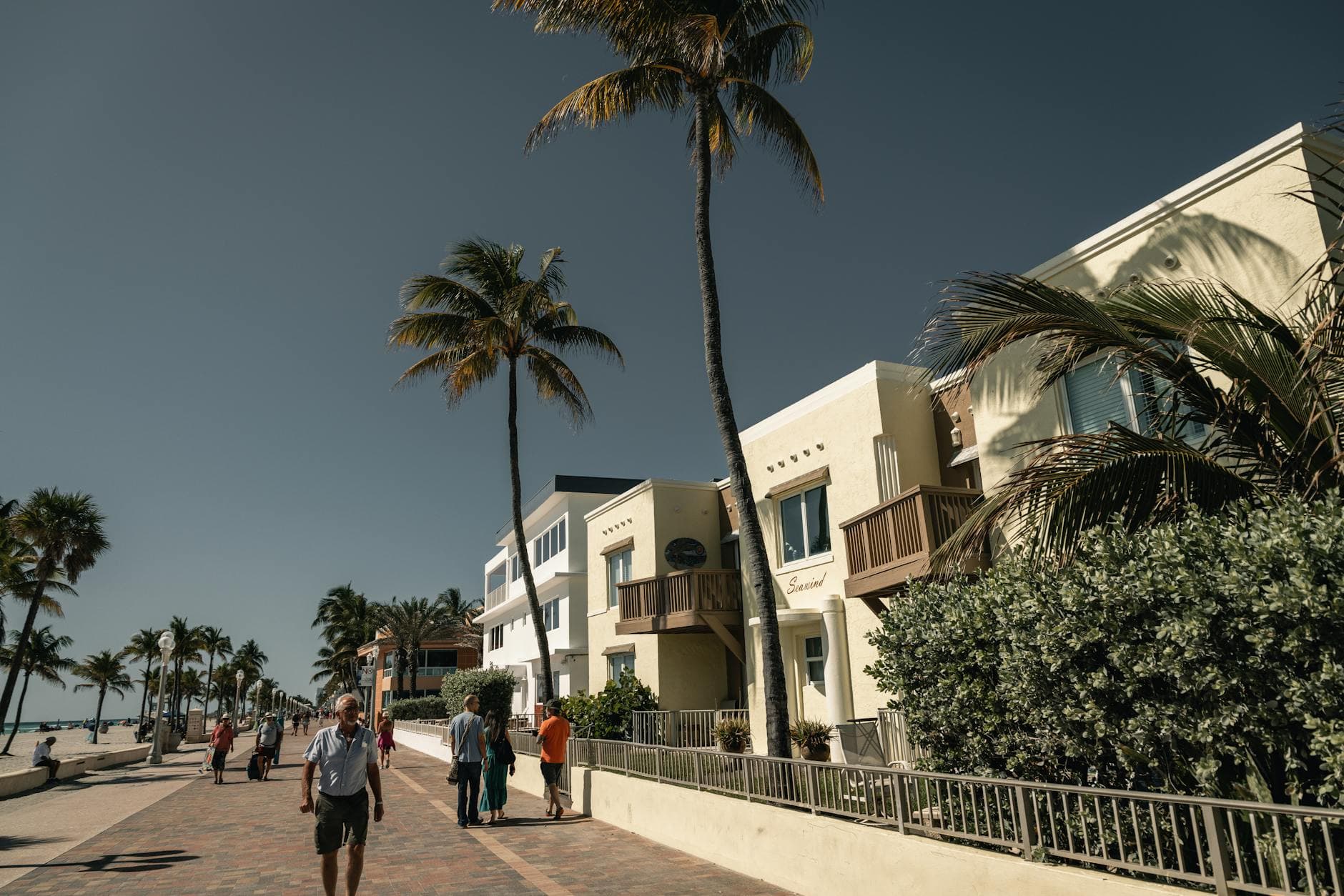 Stroll along the scenic Hollywood Beach boardwalk lined with palm trees and sunny skies.