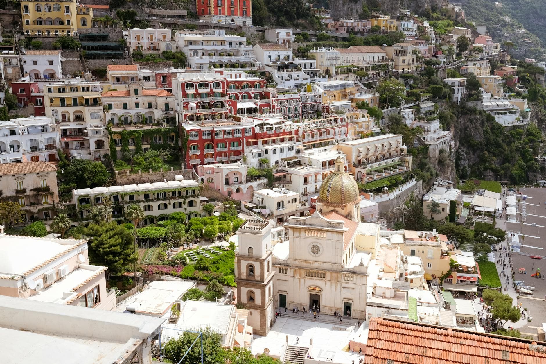 A breathtaking view of Positano, Italy, showcasing vibrant buildings and the Church of Santa Maria Assunta along the Amalfi Coast.