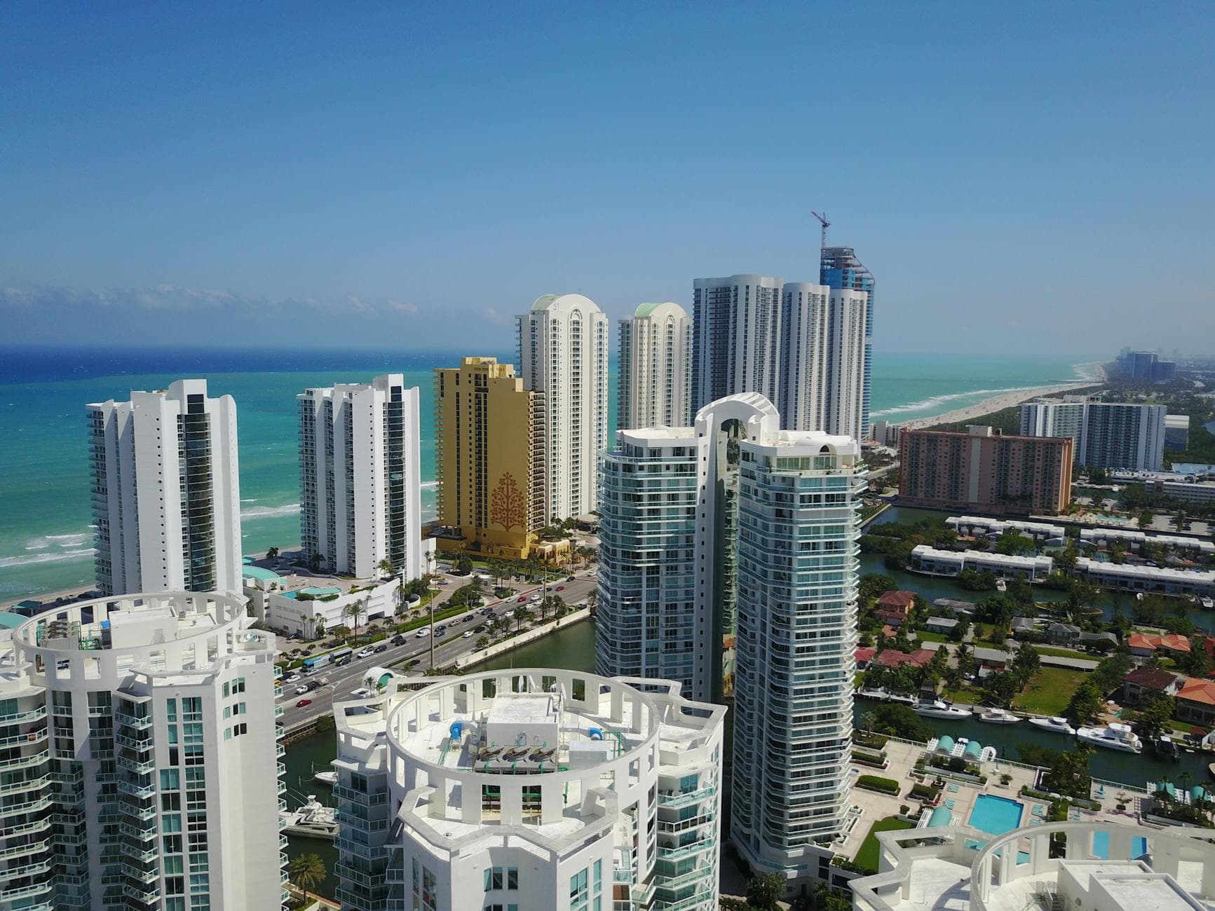 Aerial view of modern Sunny Isles Beach skyline with ocean in background.