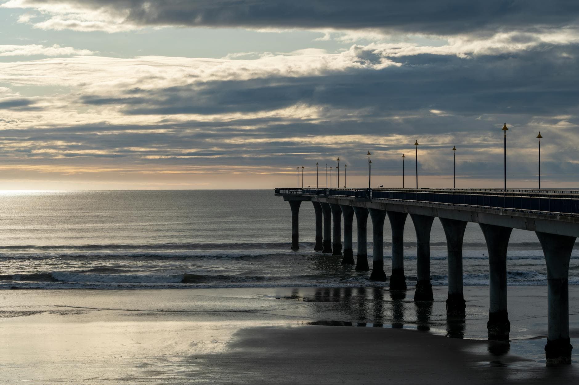 A tranquil sunset view of New Brighton Pier in Christchurch, New Zealand overlooking the Pacific Ocean.