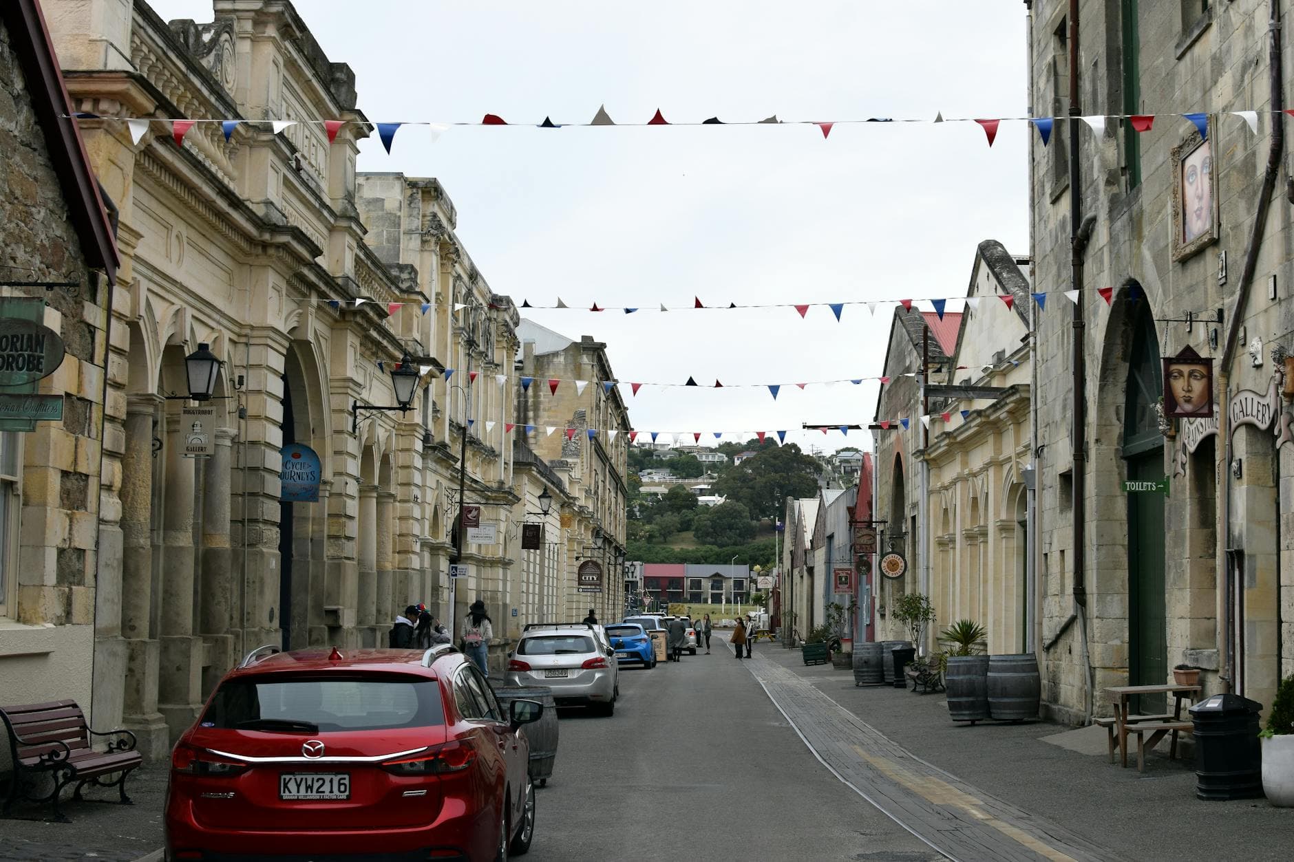 Charming view of a historic street in Oamaru, New Zealand, featuring architectural charm and bunting decoration.