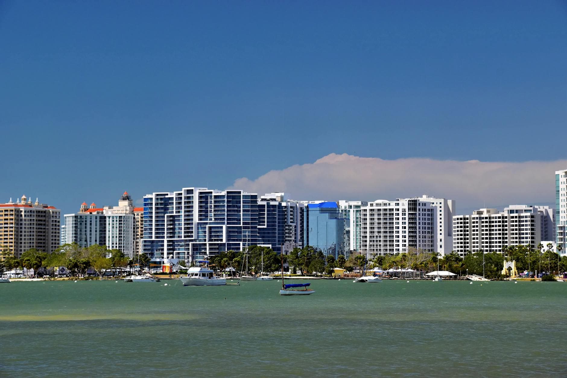 Panoramic view of Sarasota, Florida skyline against a blue sky, featuring modern architecture and waterfront.