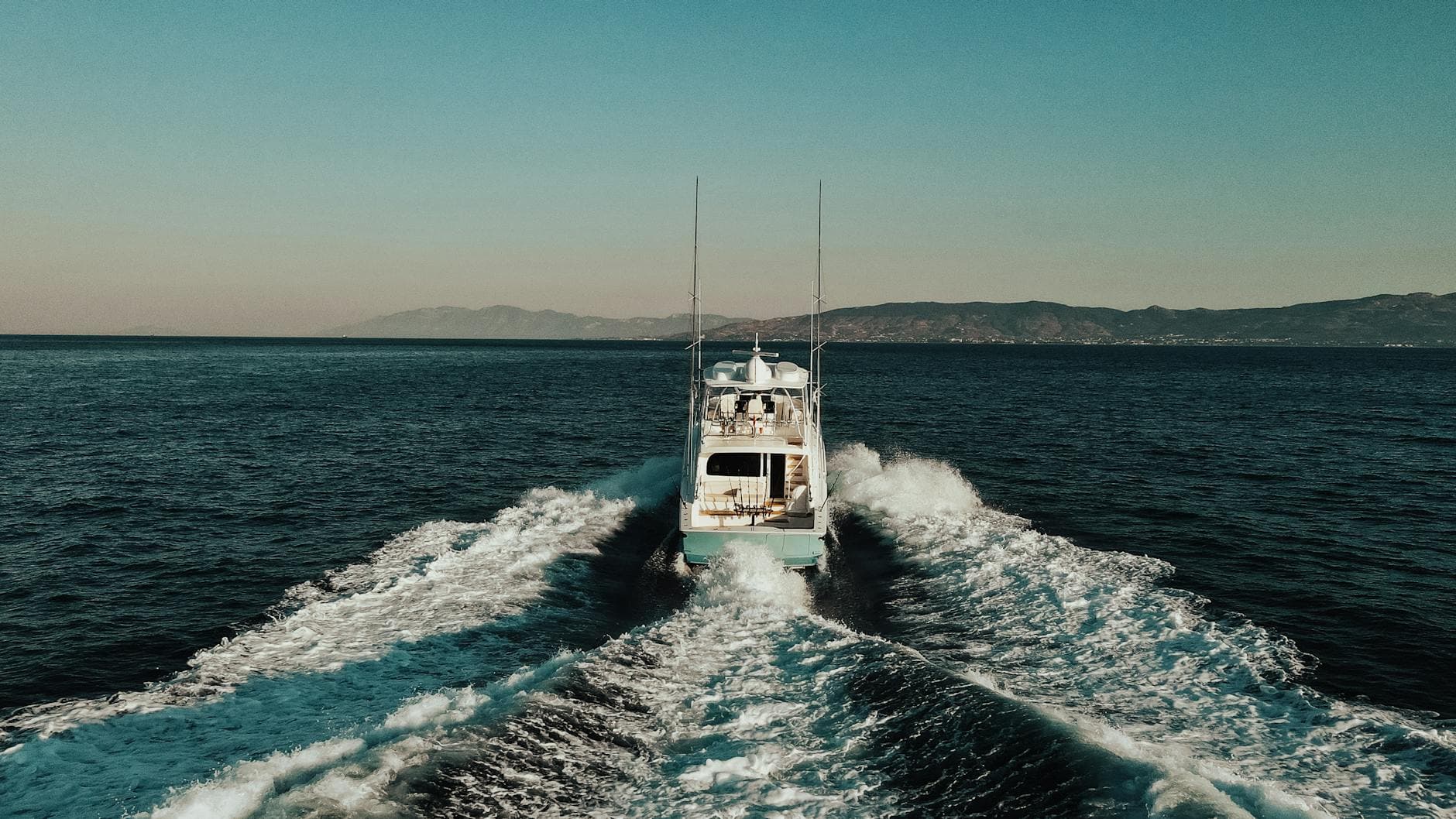 Motorboat cruising at high speed on the Aegean Sea near Yalıkavak, showcasing scenic coastal views.