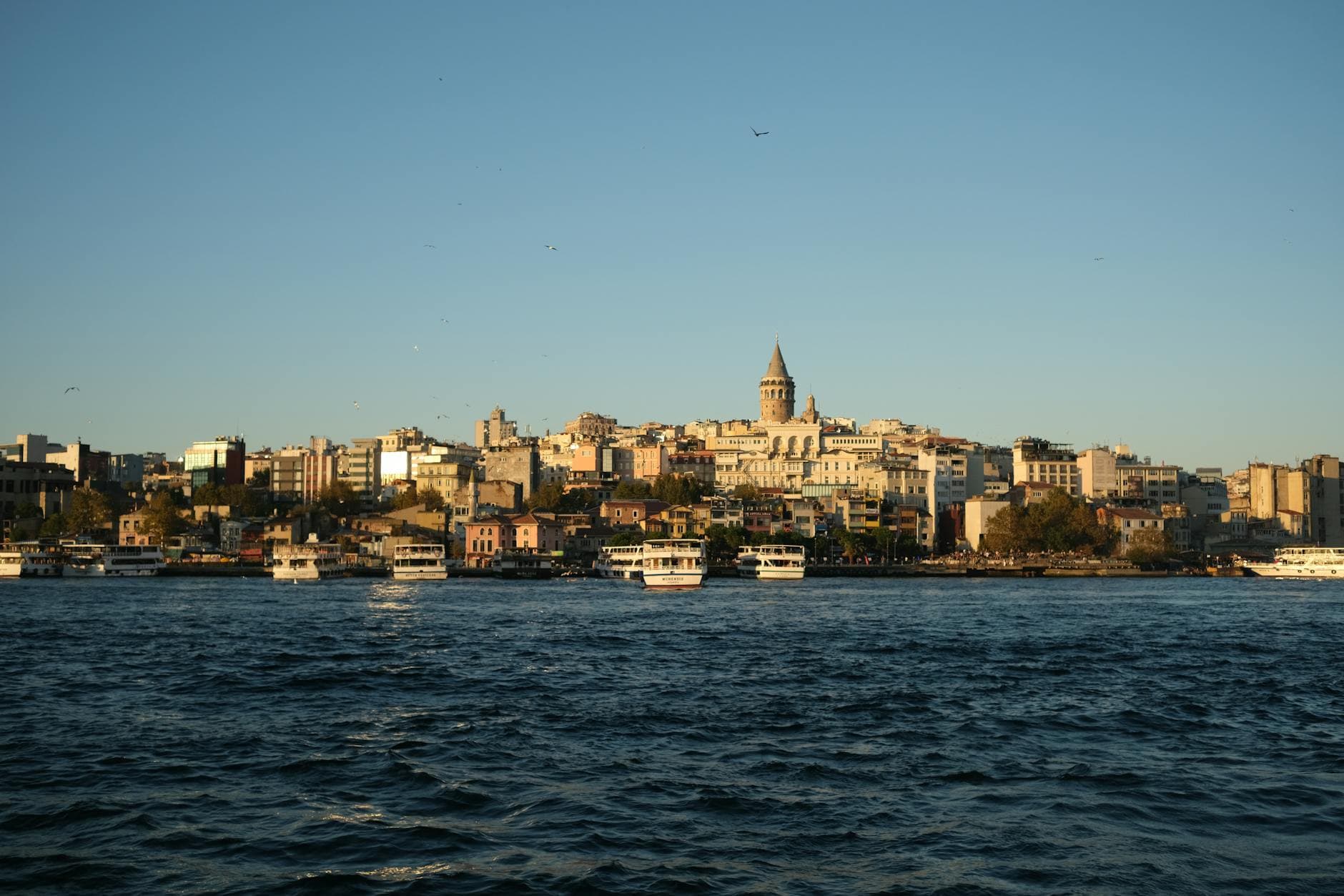 Scenic Istanbul skyline with Galata Tower viewed from the waterfront during sunset.