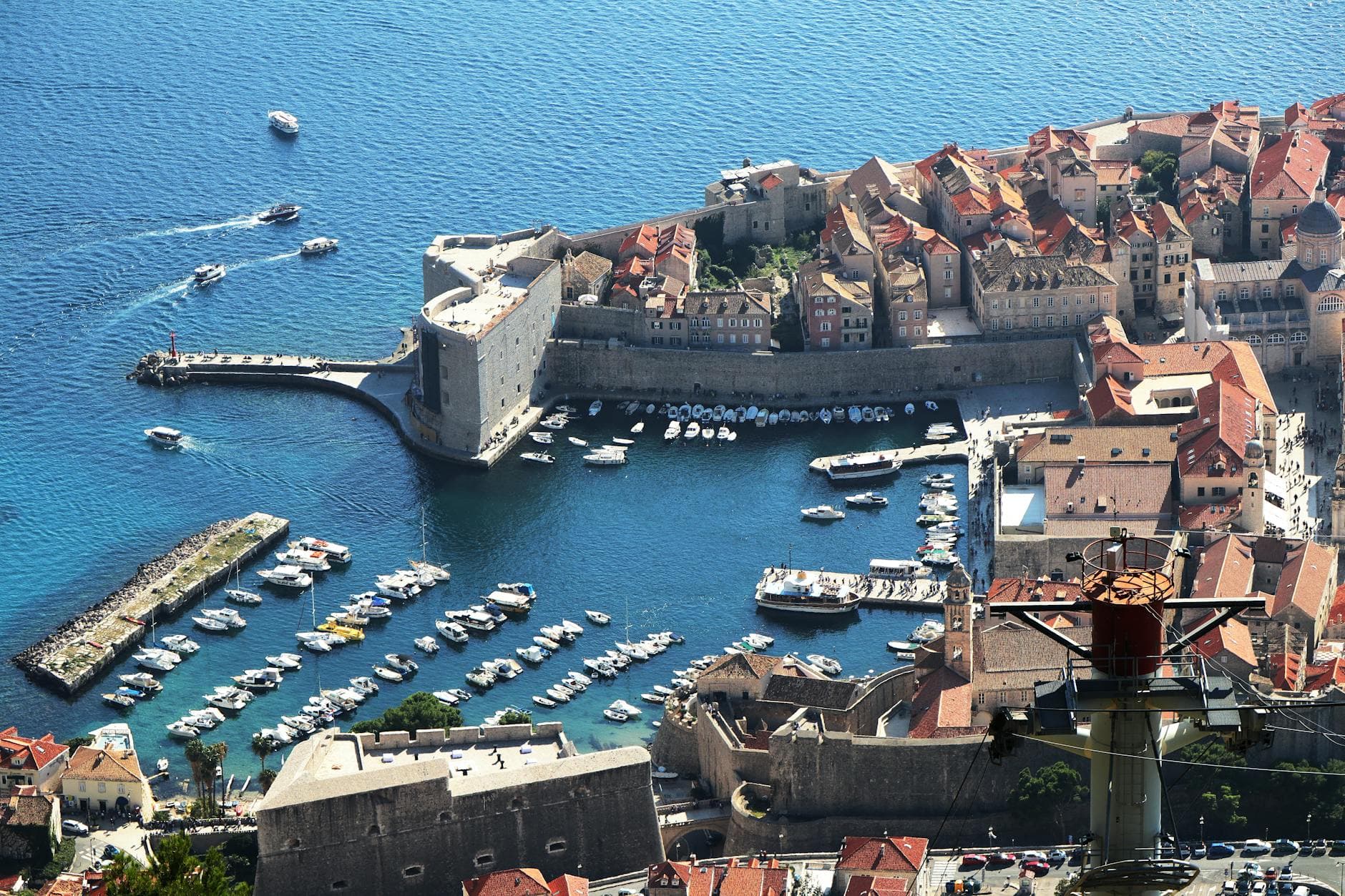 A stunning aerial view of Dubrovnik's Old Town and marina, showcasing the city's medieval architecture along Croatia's coast.