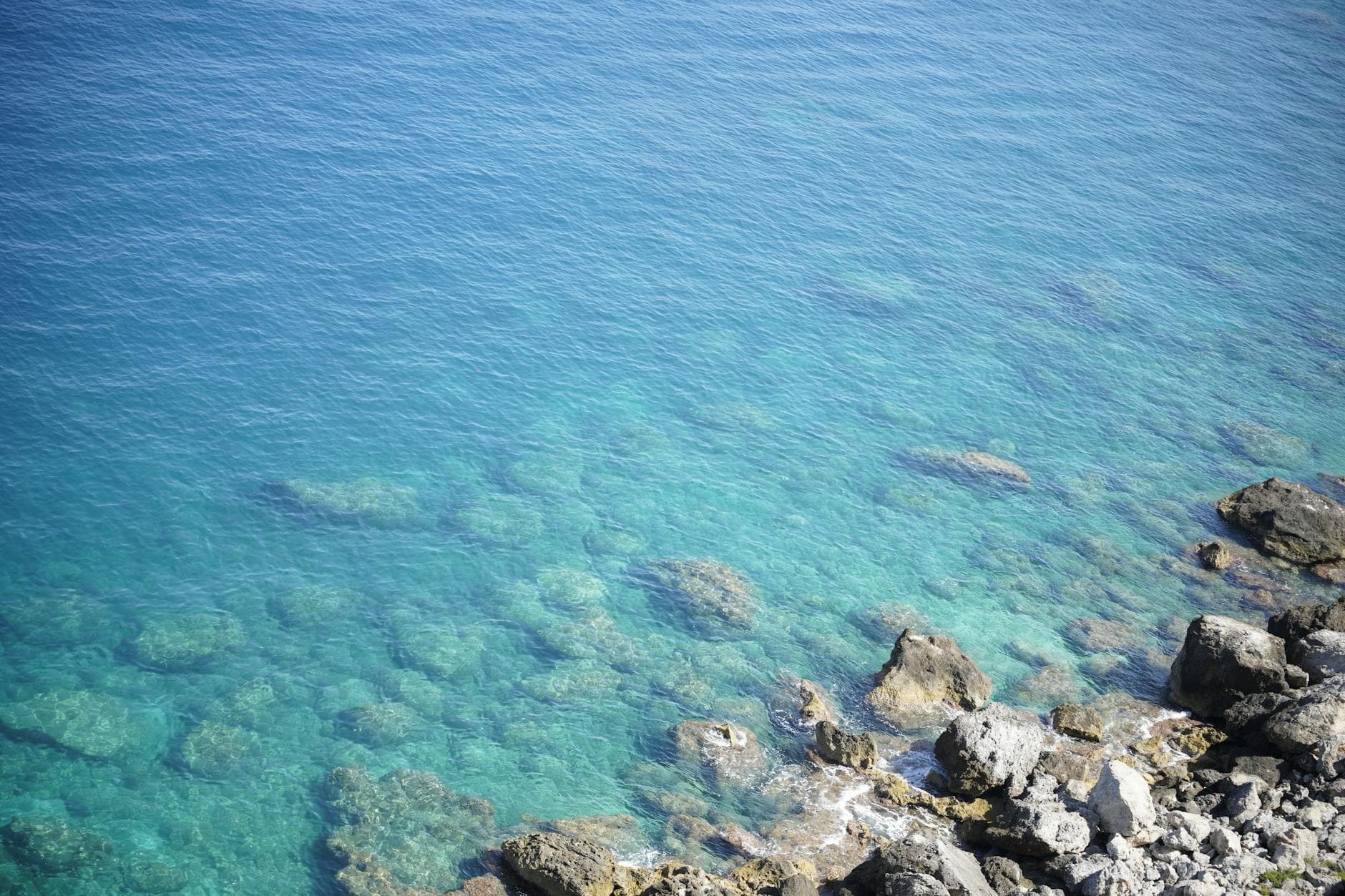 Breathtaking view of turquoise waters and rocky shoreline in San Nicola di Tremiti, Puglia, Italy.