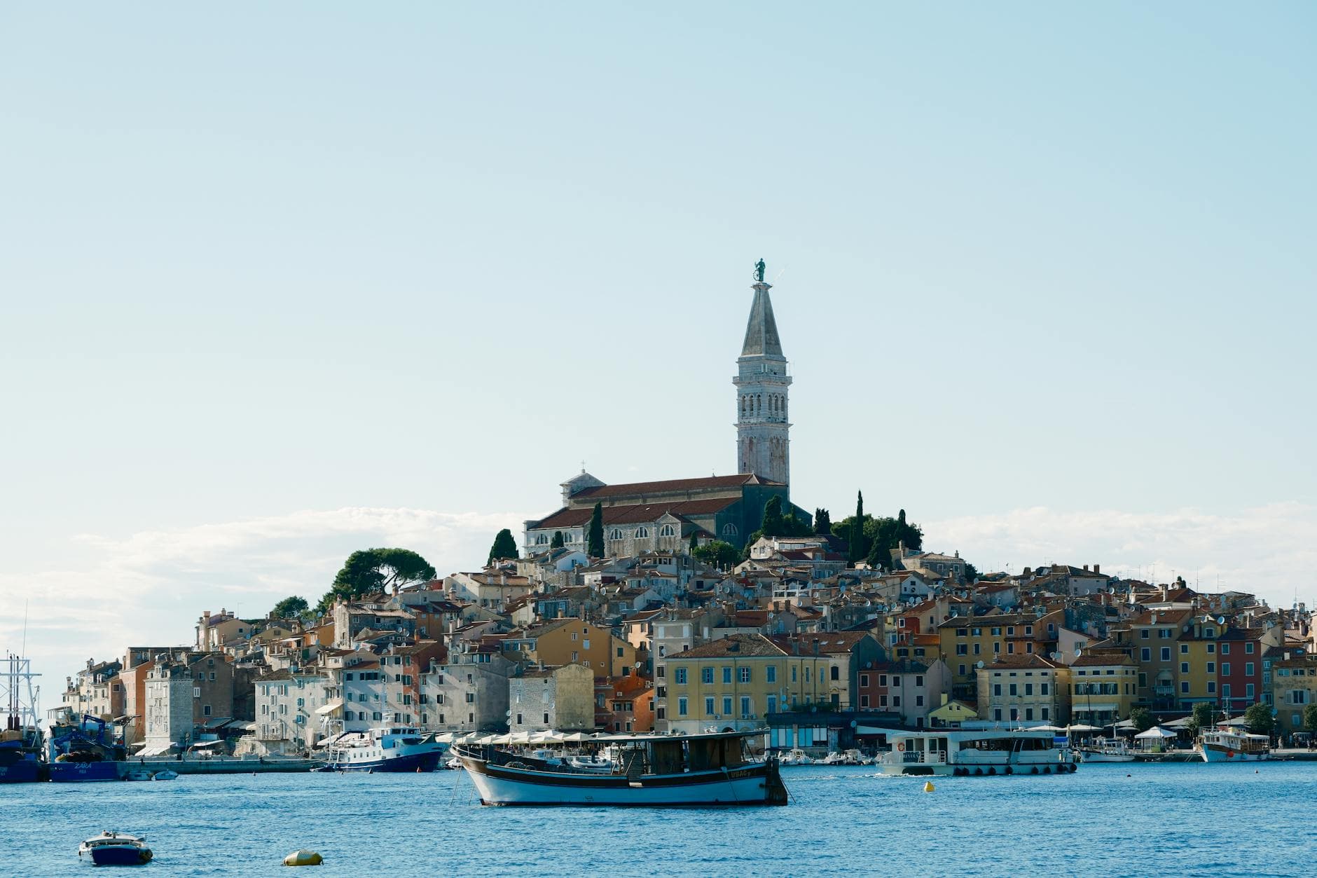 Captivating view of Rovinj's colorful buildings and iconic bell tower along the Adriatic Sea.