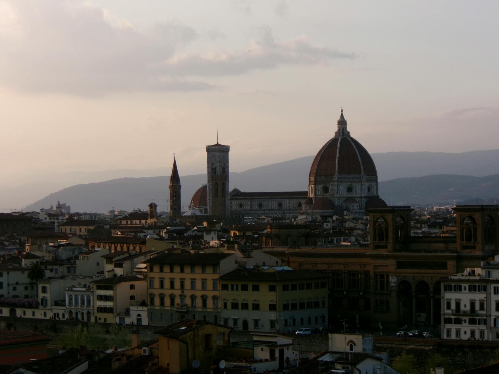 A beautiful view of Florence Cathedral's dome against a sunset sky in Florence, Italy.