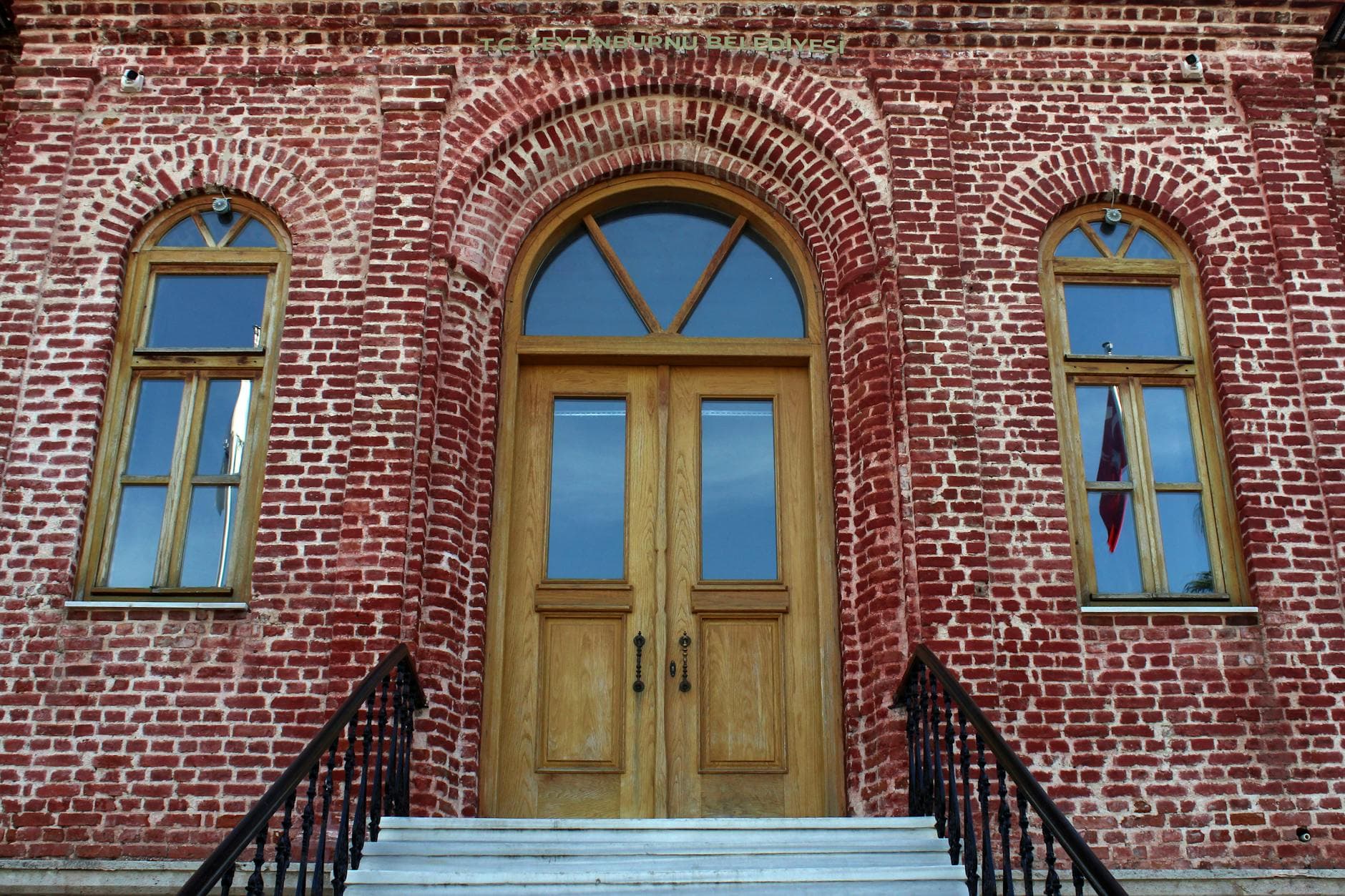 Detailed view of a historic red brick facade with arched doorway and windows in Zeytinburnu, Istanbul.