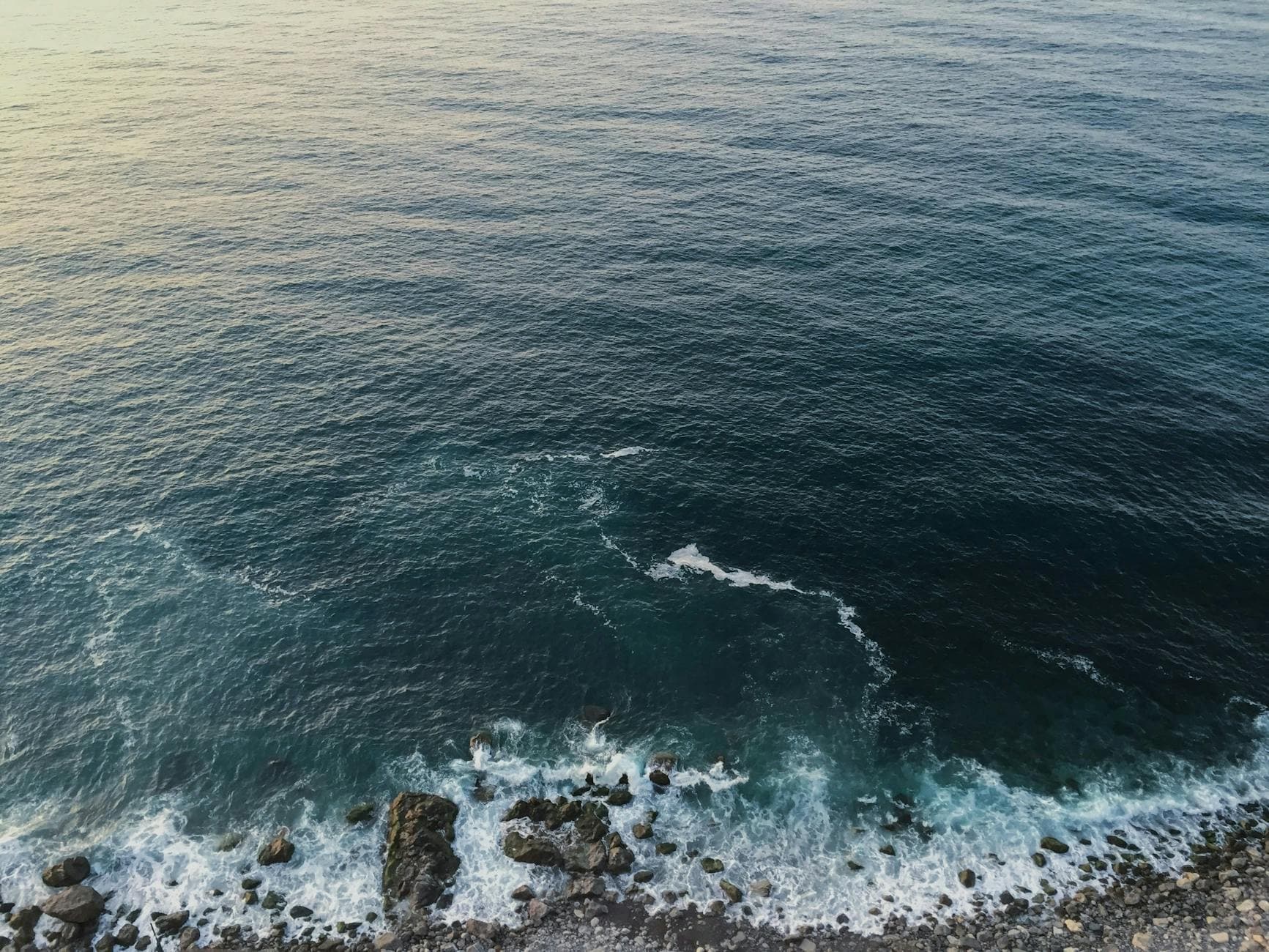 Calm ocean waves hitting the rocky shoreline of Zonguldak, Türkiye at dusk.
