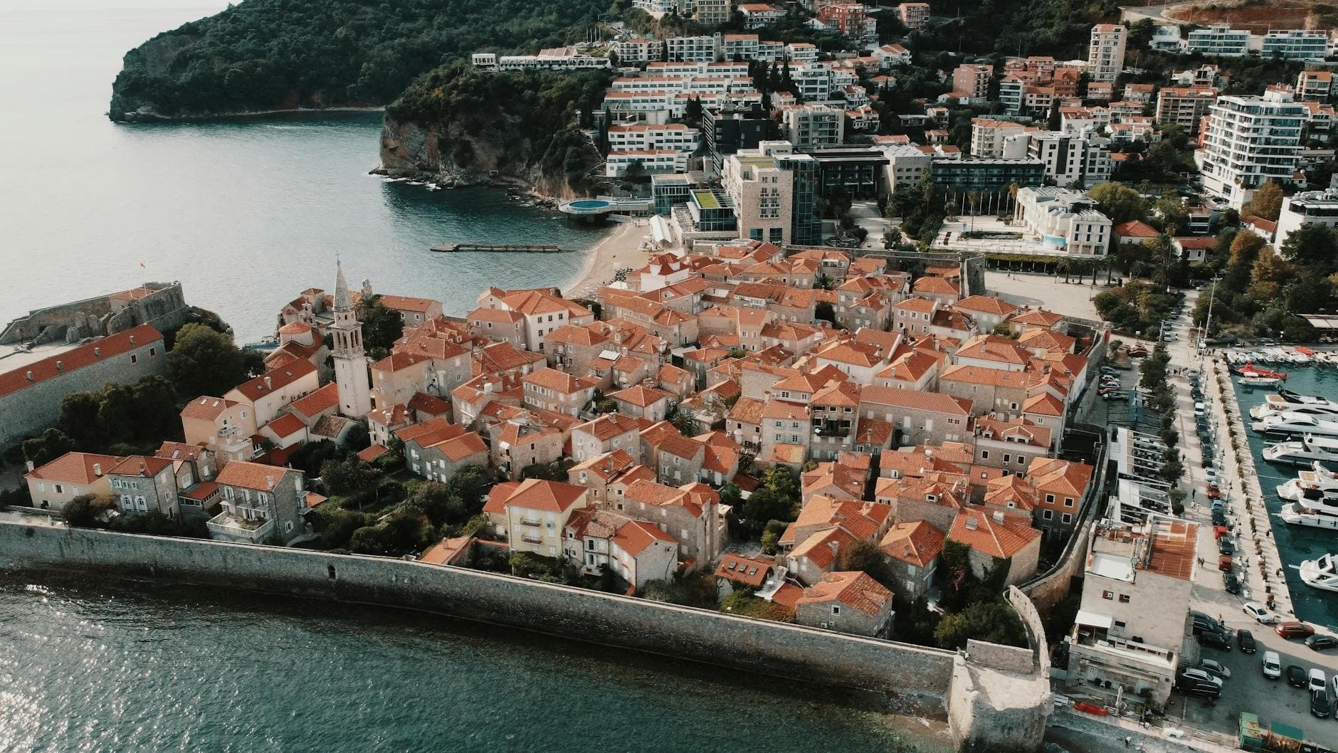 Stunning aerial view of Budva Old Town in Montenegro with red roofs and coastline.