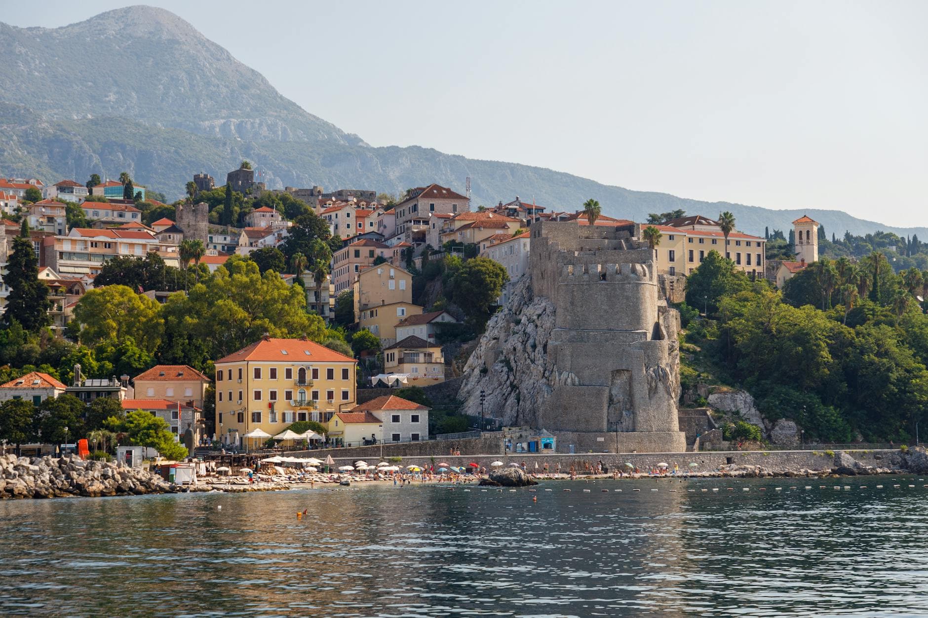 Explore the stunning coastal view of Herceg Novi, Montenegro with the historic Kanli Kula tower by the Adriatic Sea.