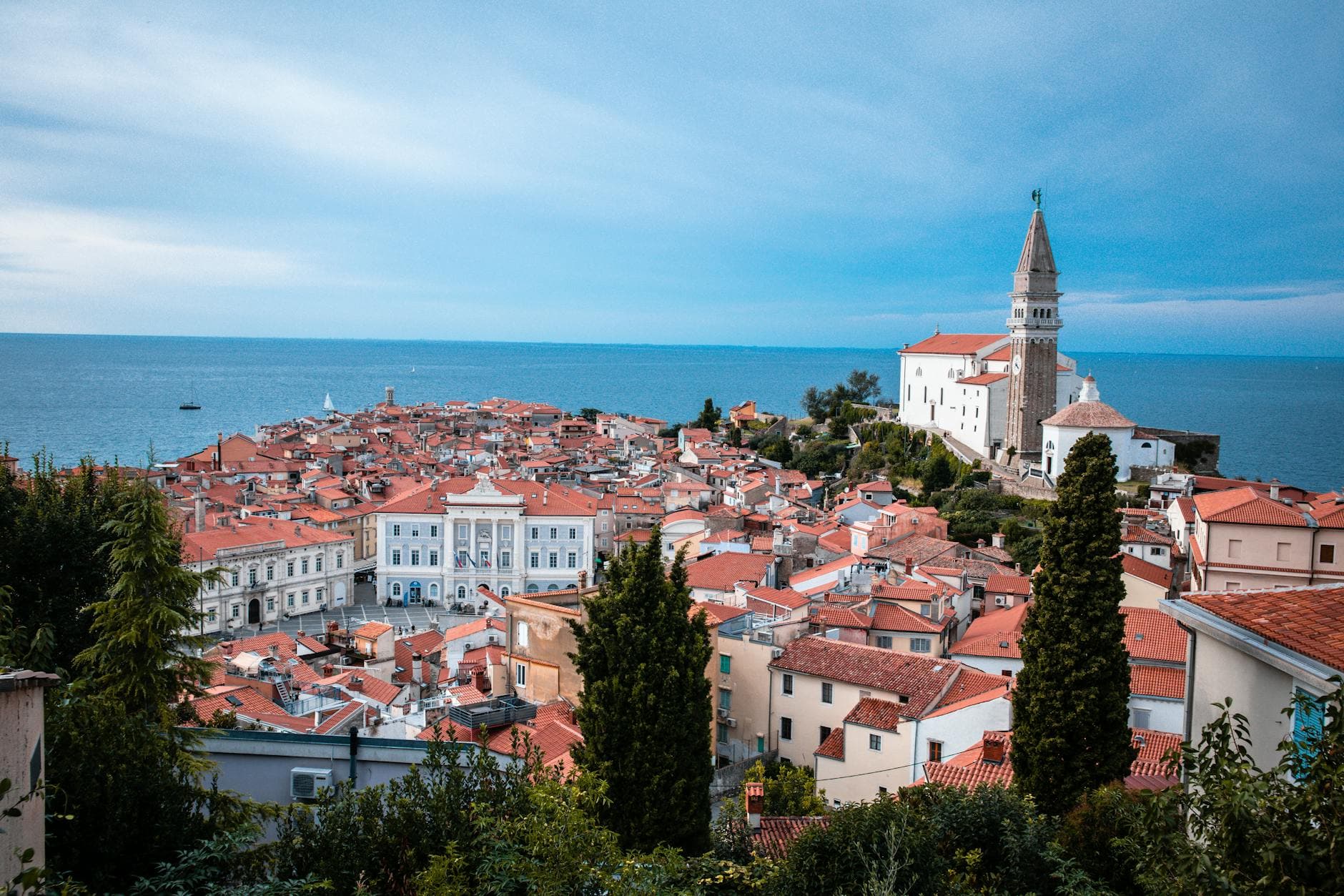 Scenic view of a coastal town featuring historic buildings and church by the sea.