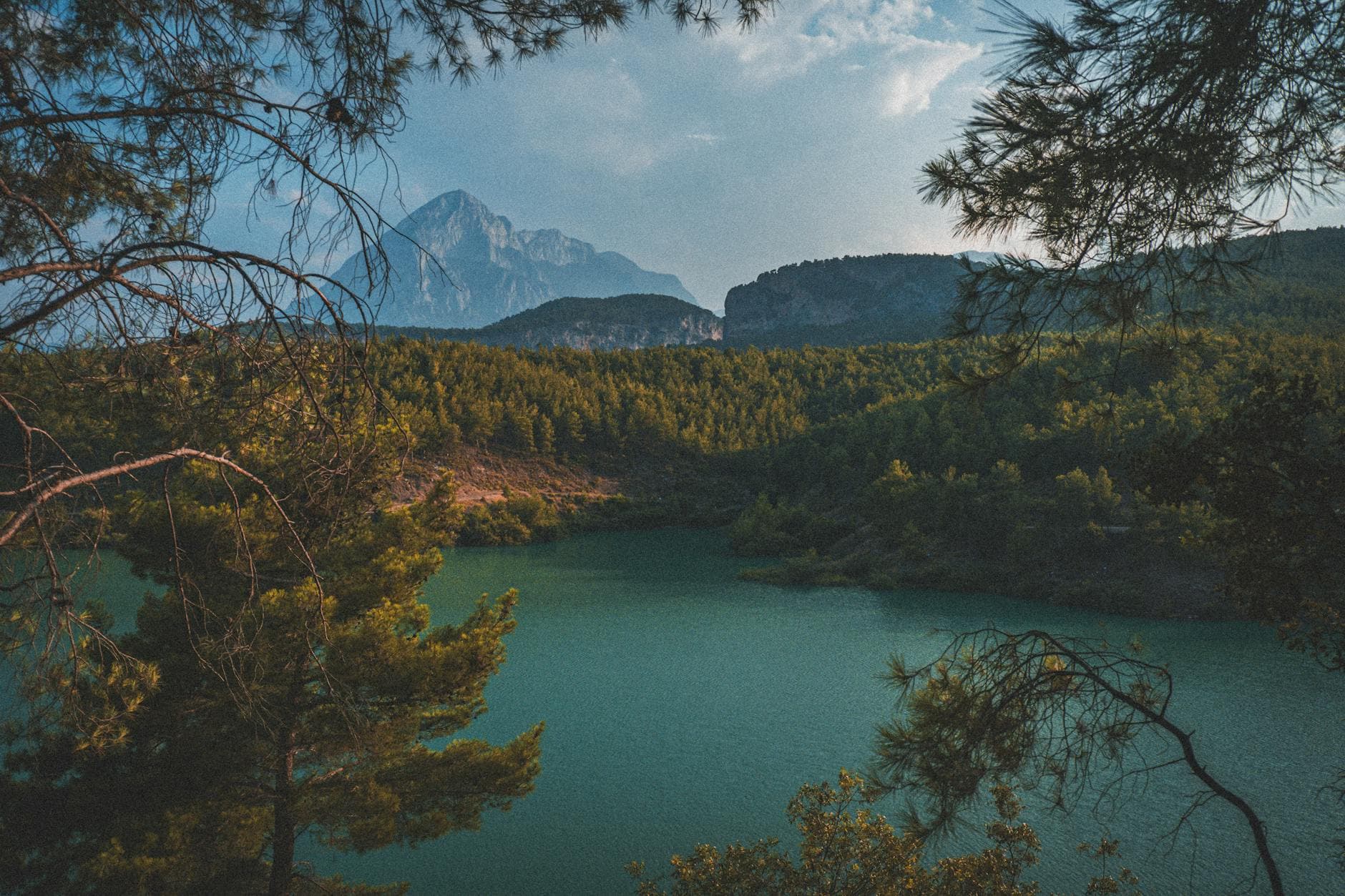 Scenic view of Doyran Pond surrounded by lush forest and mountains in Antalya, Turkey.