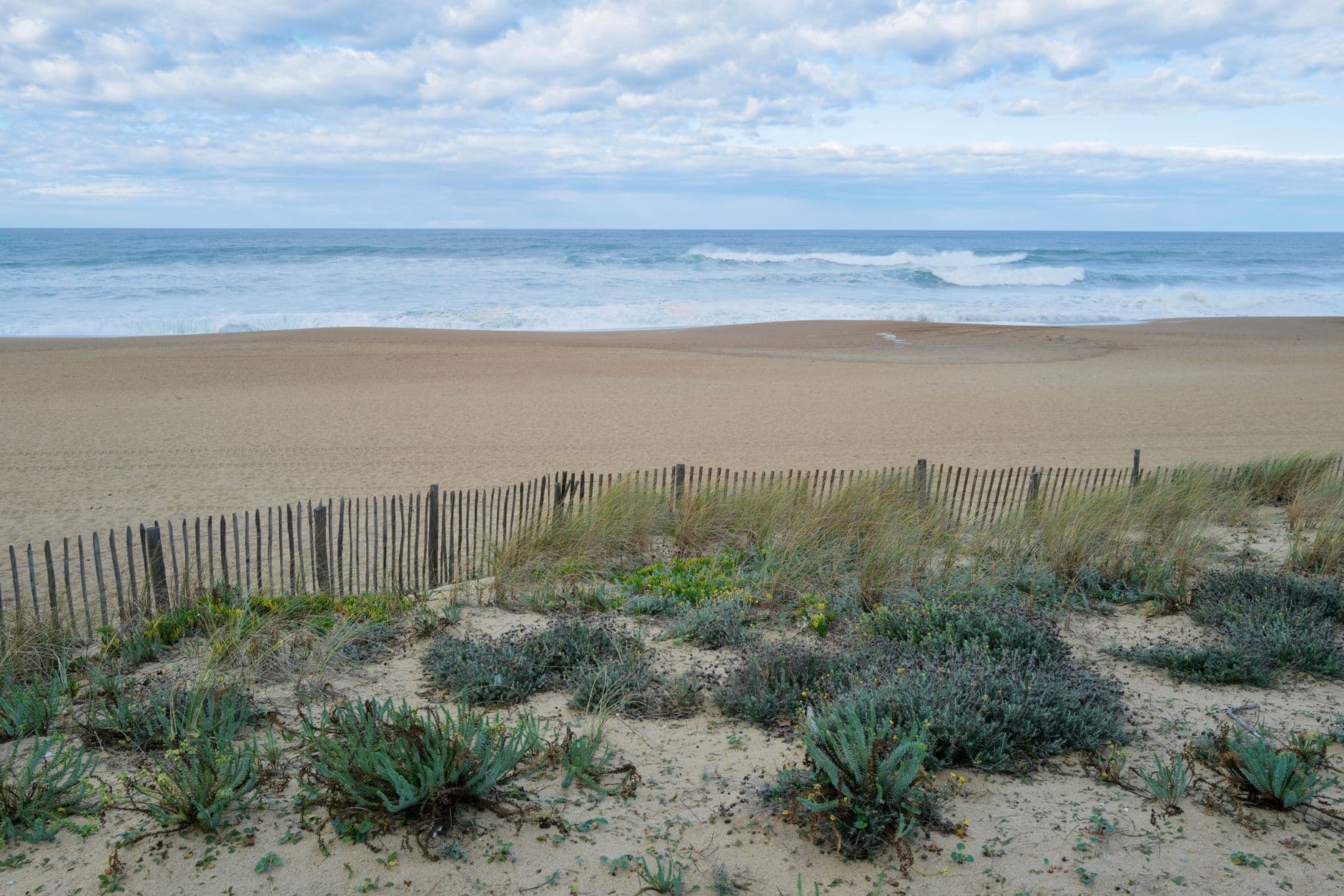 Peaceful beach scene at Anglet, France with sandy dunes and ocean waves.
