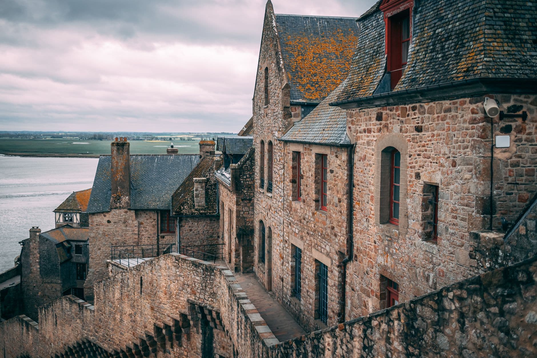 Explore the medieval architecture of Mont Saint-Michel in Normandy, France, overlooking serene coastal waters.