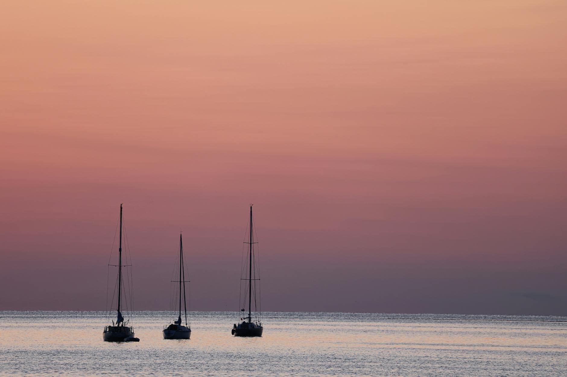 Serene view of sailboats at sunset in Norwalk Bay, capturing peaceful ocean vibes.