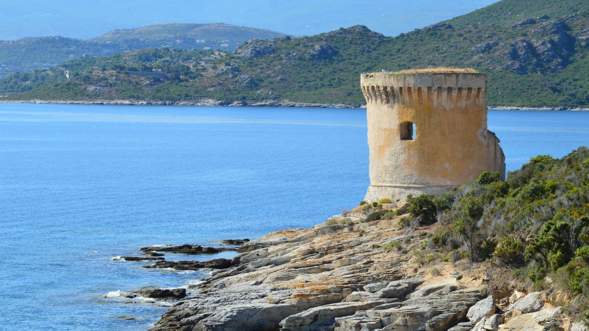 Historical Genoese tower with scenic coastal view in Saint-Florent, Corsica, France.