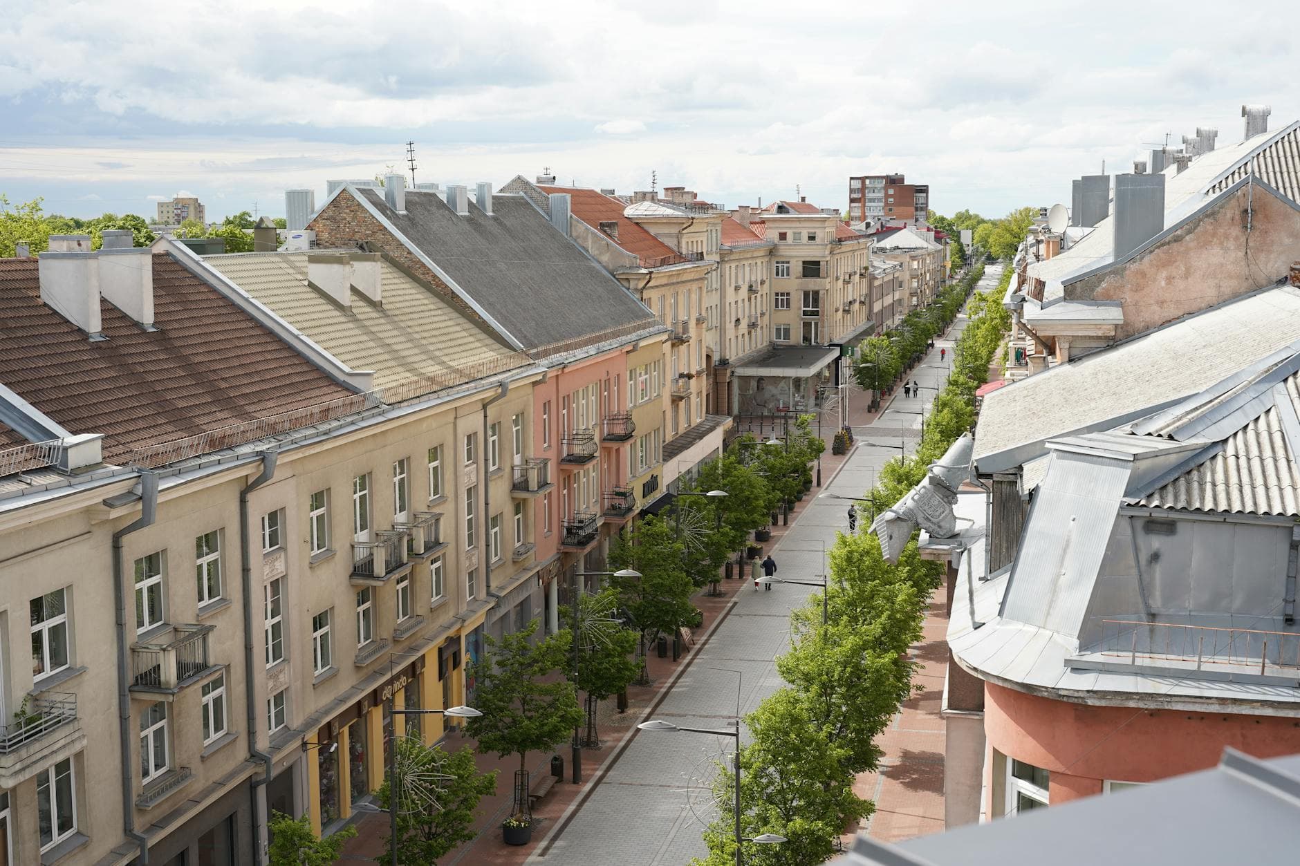 A scenic aerial view of Vilniaus Street in Šiauliai, showcasing its charming architecture and tree-lined promenade.