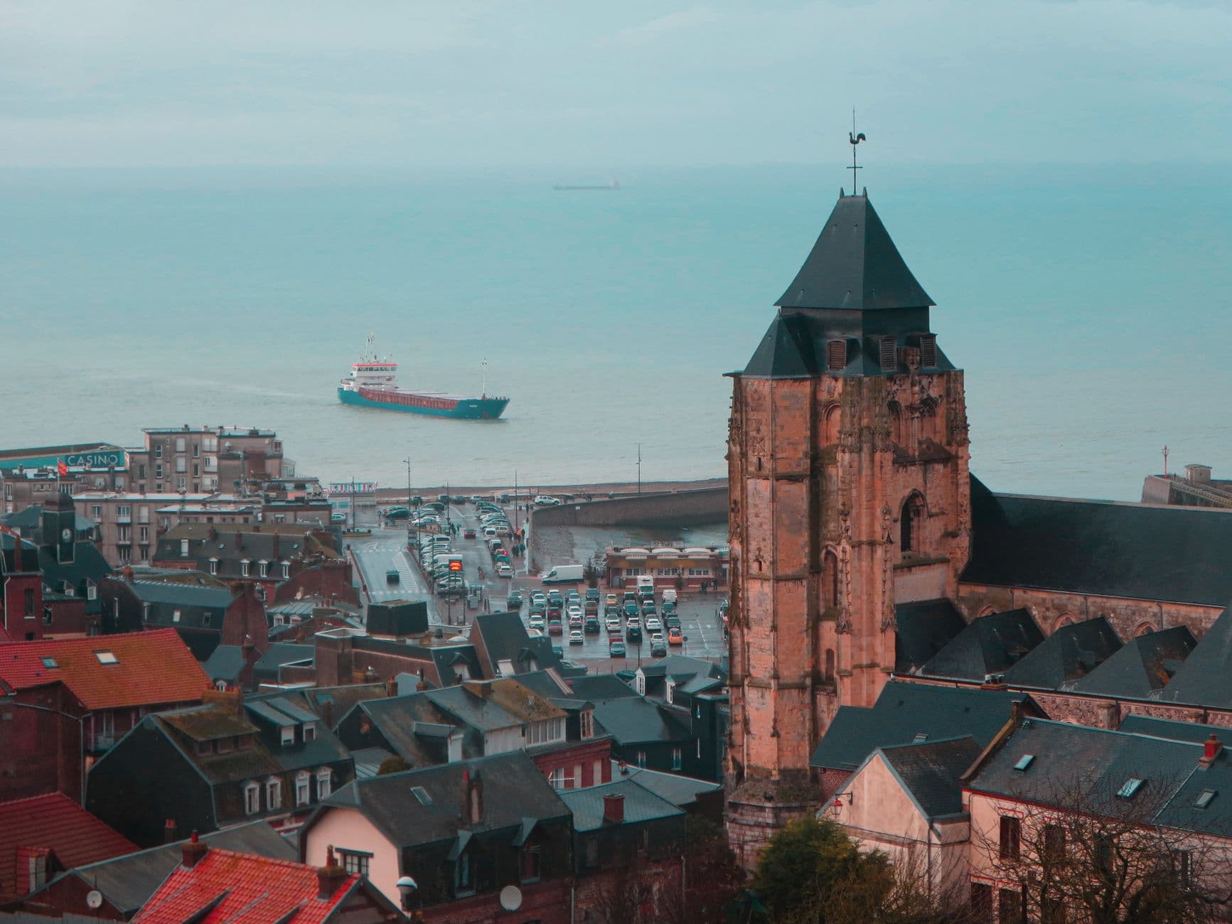 A stunning aerial view of a historic church and town by the sea in Normandy, France.